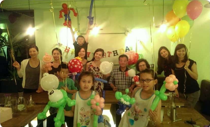 咖啡廳生日派對大合照，大人小孩拿著各式造型氣球