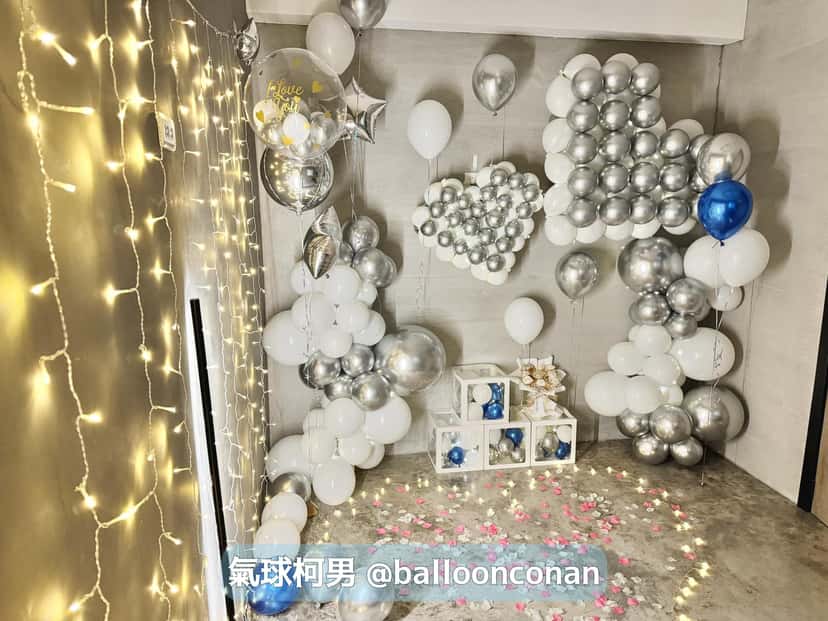 銀色氣球拼成的愛心與雲朵，下方疊著透明氣球禮物盒