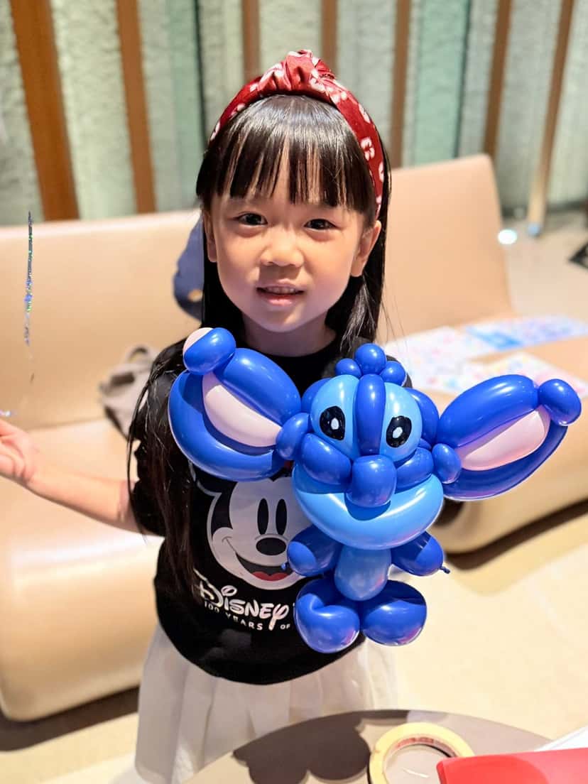 1 月生日派對：紅髮帶女孩抱著藍色史迪奇造型氣球