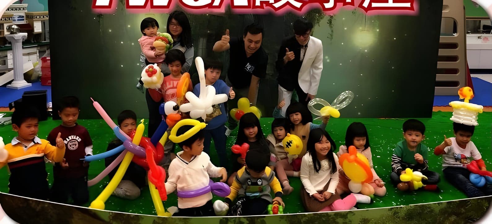 故事屋結束後，小朋友拿著氣球禮物在舞台草皮上大合照