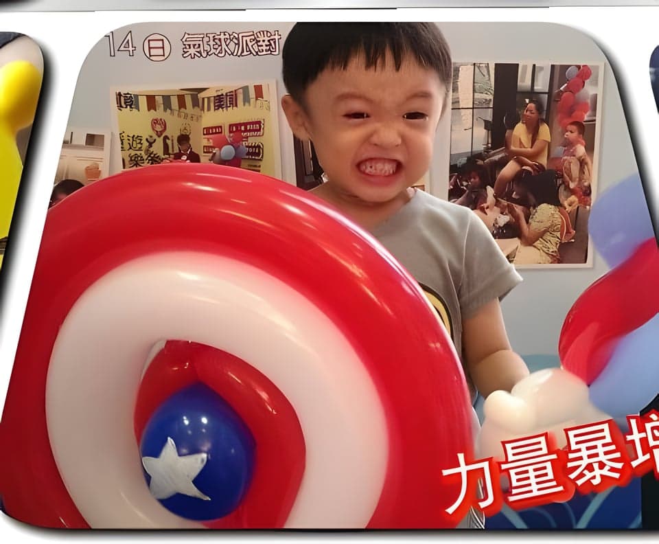 小男孩舉著美國隊長盾牌氣球，寫著力量暴增