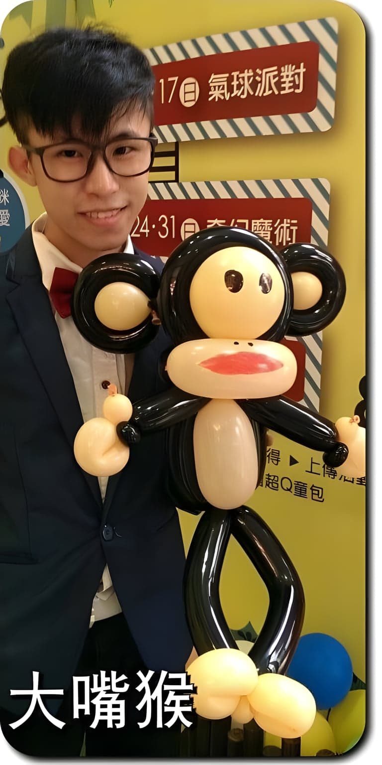 柯男拿著黑色大嘴猴造型氣球，紅色大嘴巴