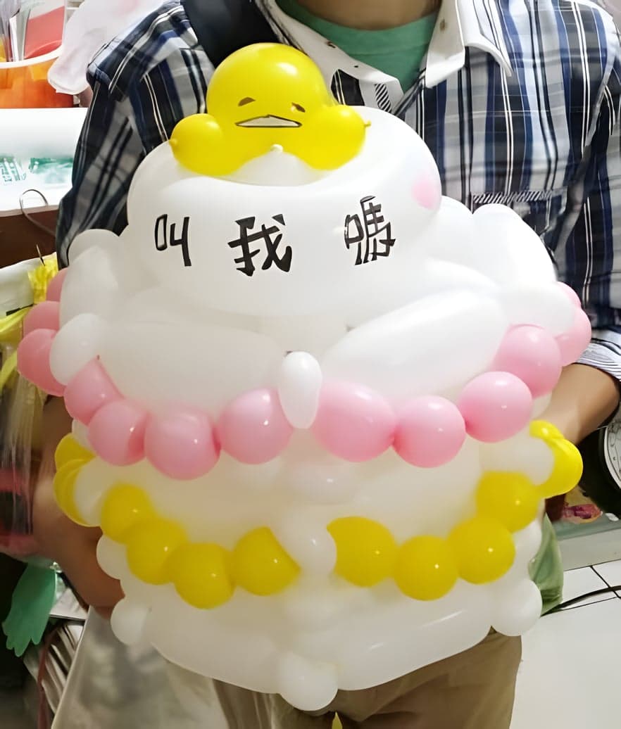 蛋黃哥蛋糕帽特寫，粉紅與黃色小球圍成蛋糕裝飾
