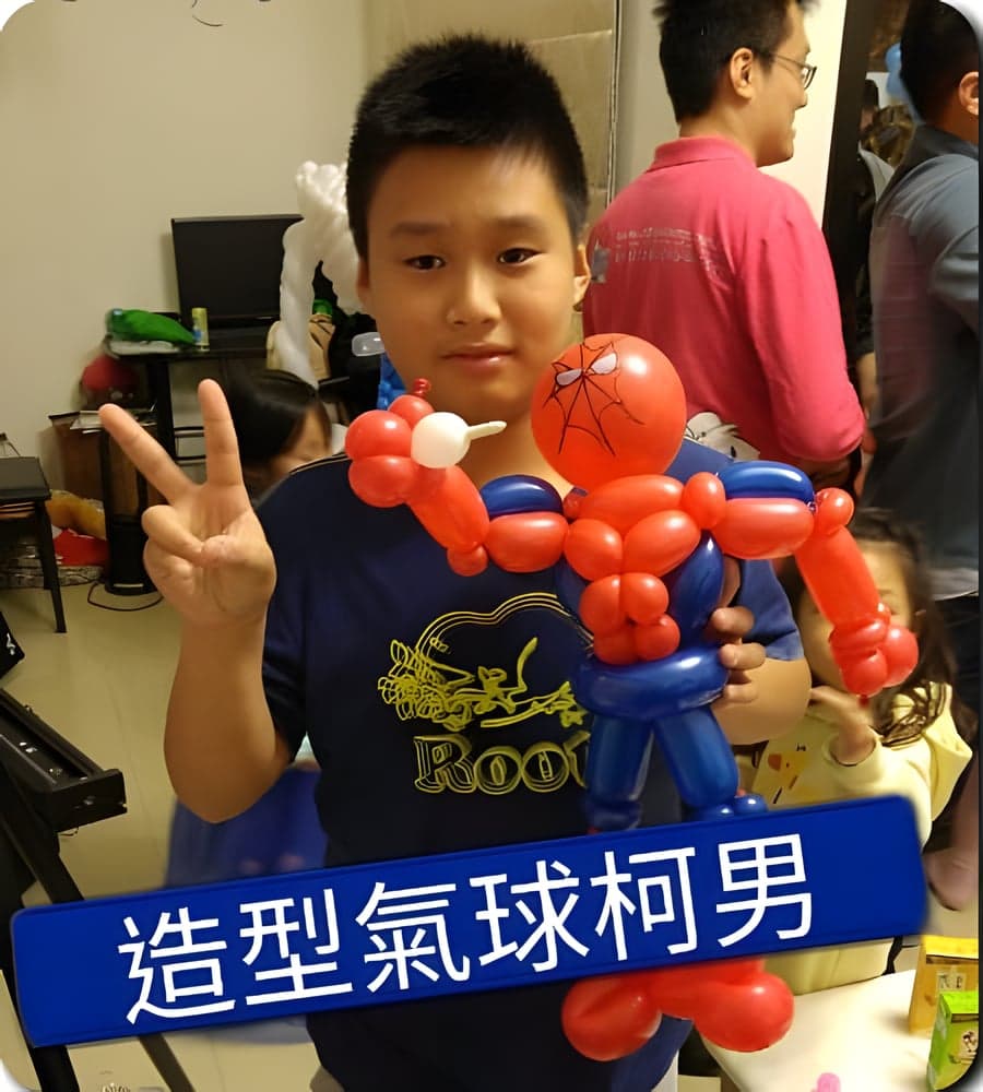 男孩比 YA 拿著紅藍色蜘蛛人造型氣球