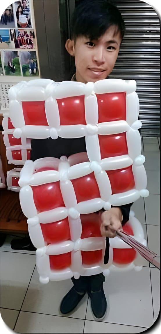 我拿著和半身一樣大的紅白數字 2 造型氣球