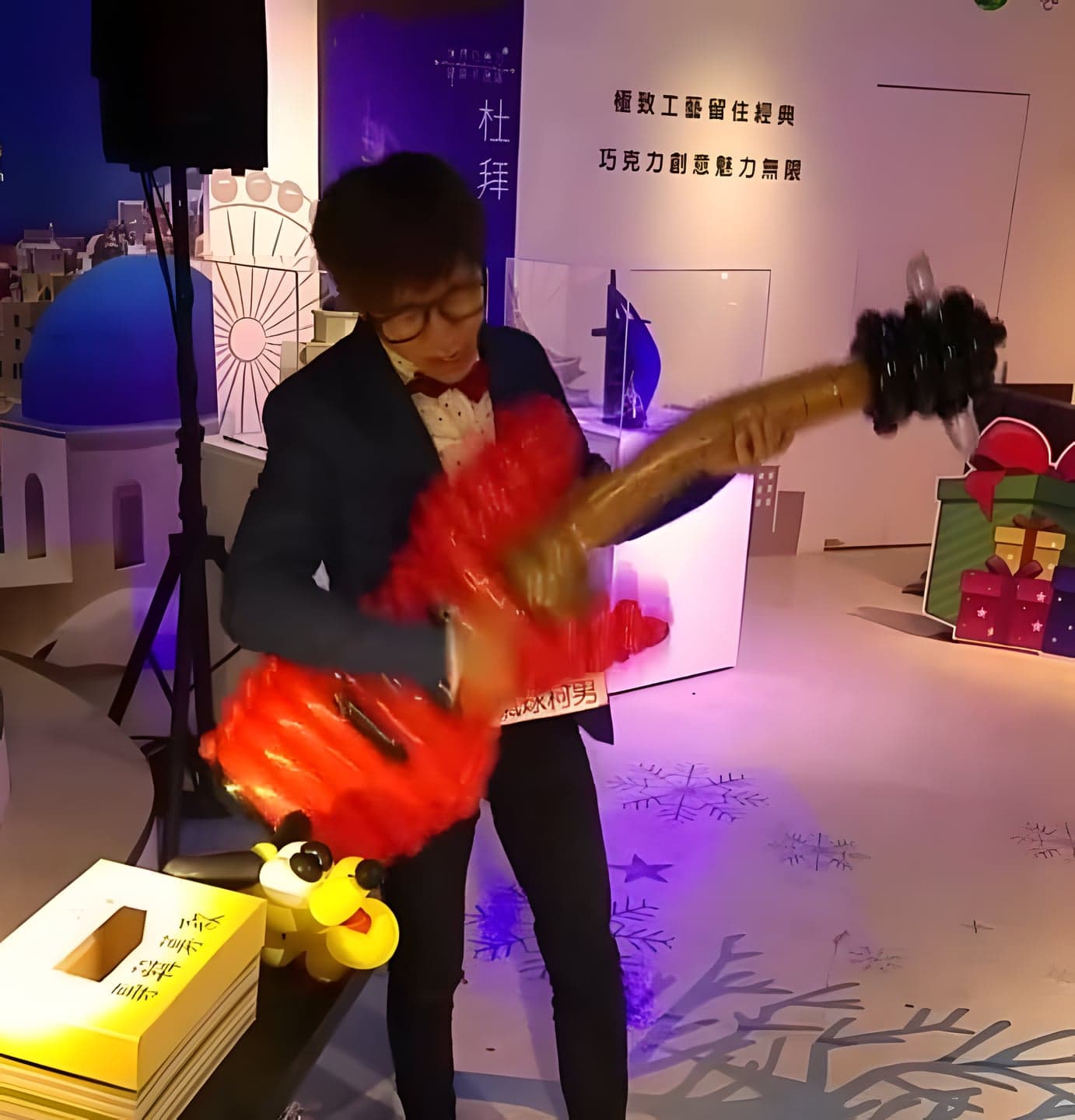 淡水巧克力夢公園舞台上，柯男抱著紅色氣球電吉他表演