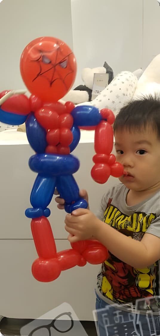 小男孩抱著紅藍色蜘蛛人造型氣球