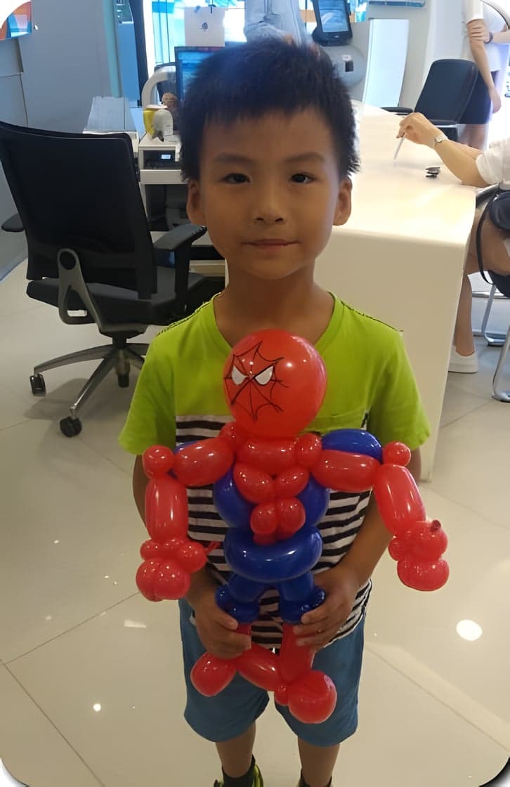 男孩抱著蜘蛛人造型氣球站在銀行大廳