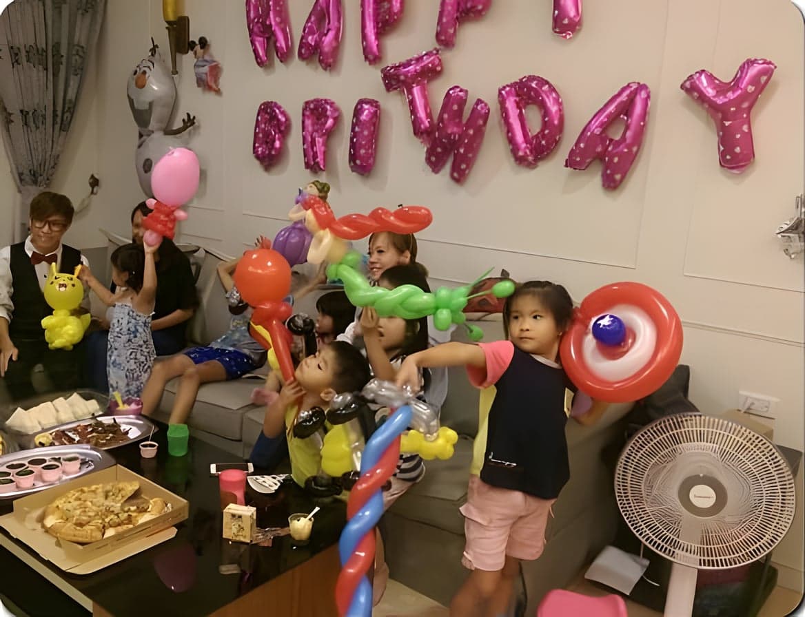 淡水居家生日派對客廳，HAPPY BIRTHDAY 字母氣球下拿著造型氣球的小朋友