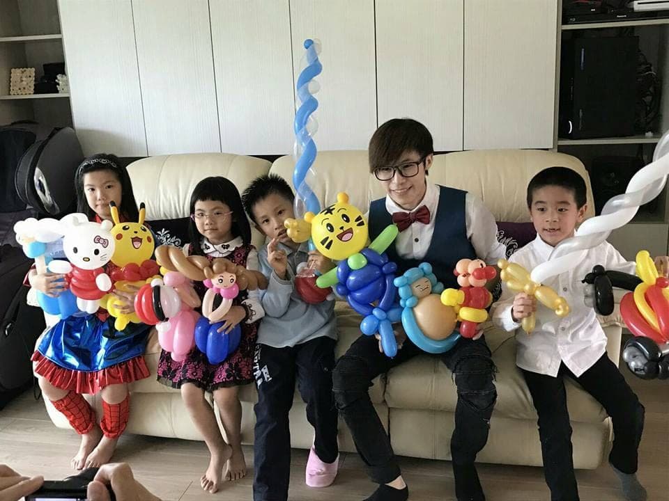 居家生日派對，小朋友在沙發上抱著 Hello Kitty、皮卡丘、巧虎造型氣球合照