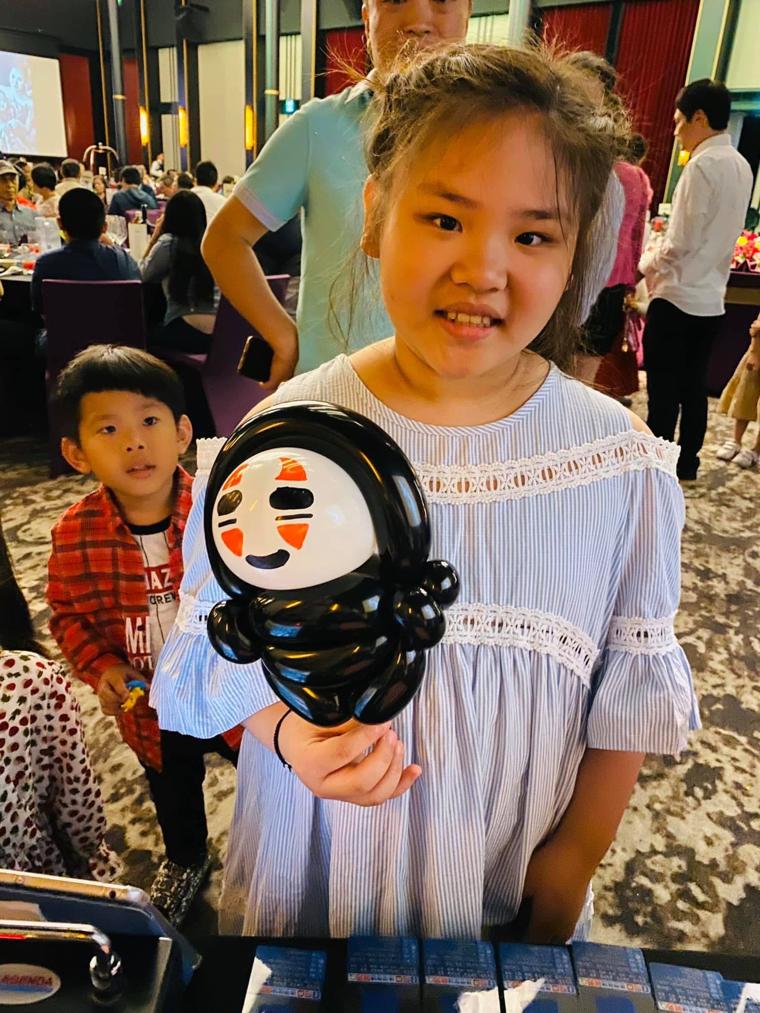 女孩拿著黑身白面具的無臉男造型氣球