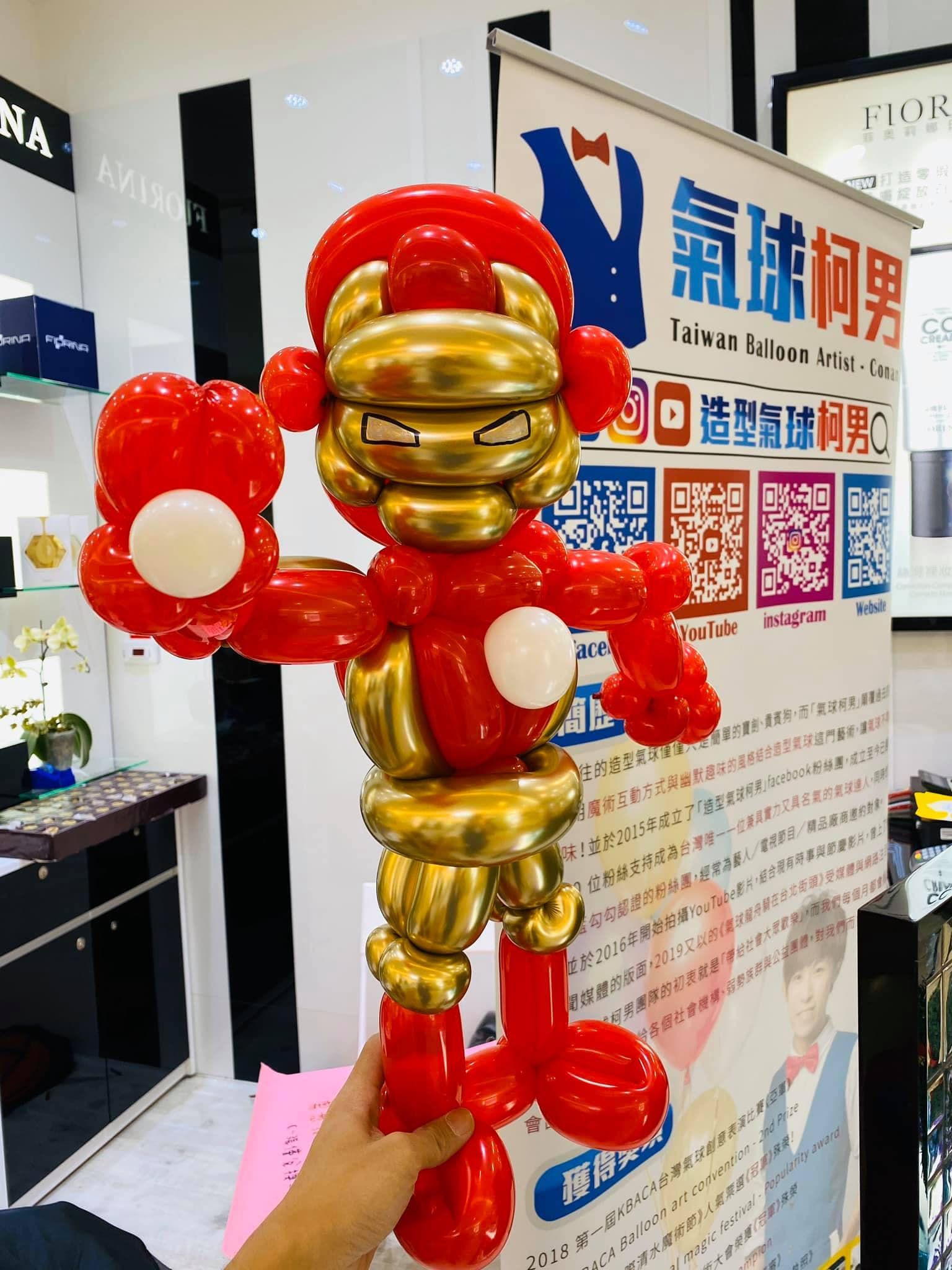 紅色與金色金屬氣球做的鋼鐵人，背景是氣球柯男立牌