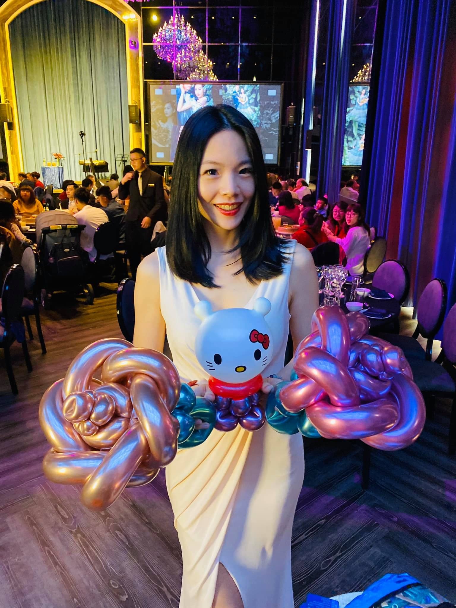 穿白色洋裝的女生拿著 Hello Kitty 和兩朵金屬玫瑰