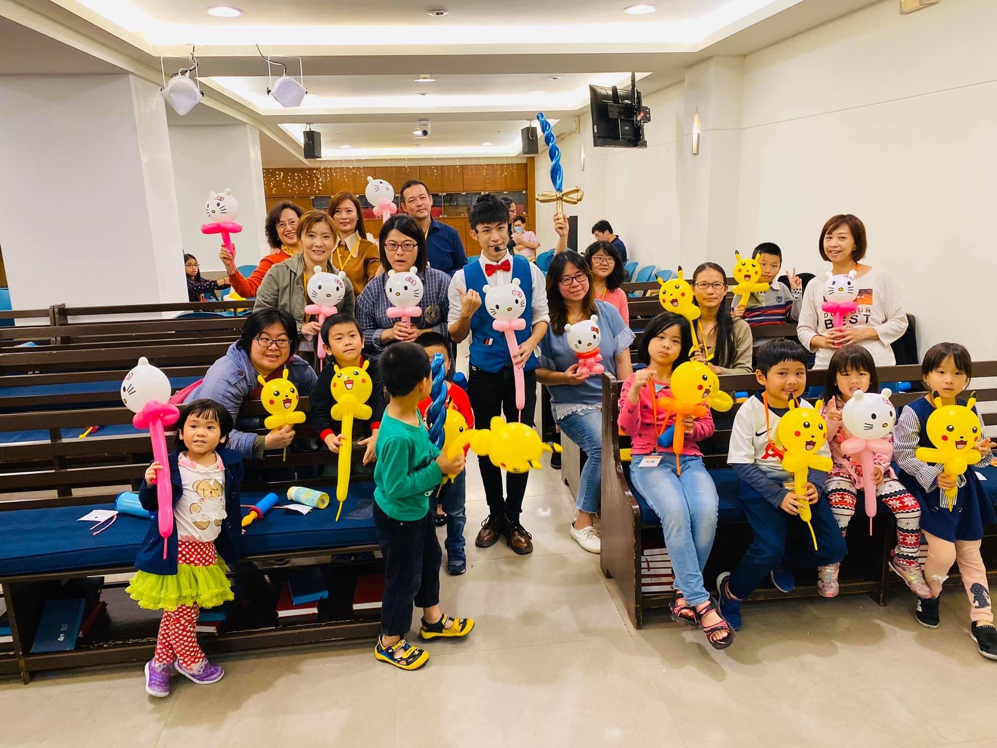 教會禮拜堂長椅前，孩子們舉著皮卡丘、Hello Kitty 手持棒大合照