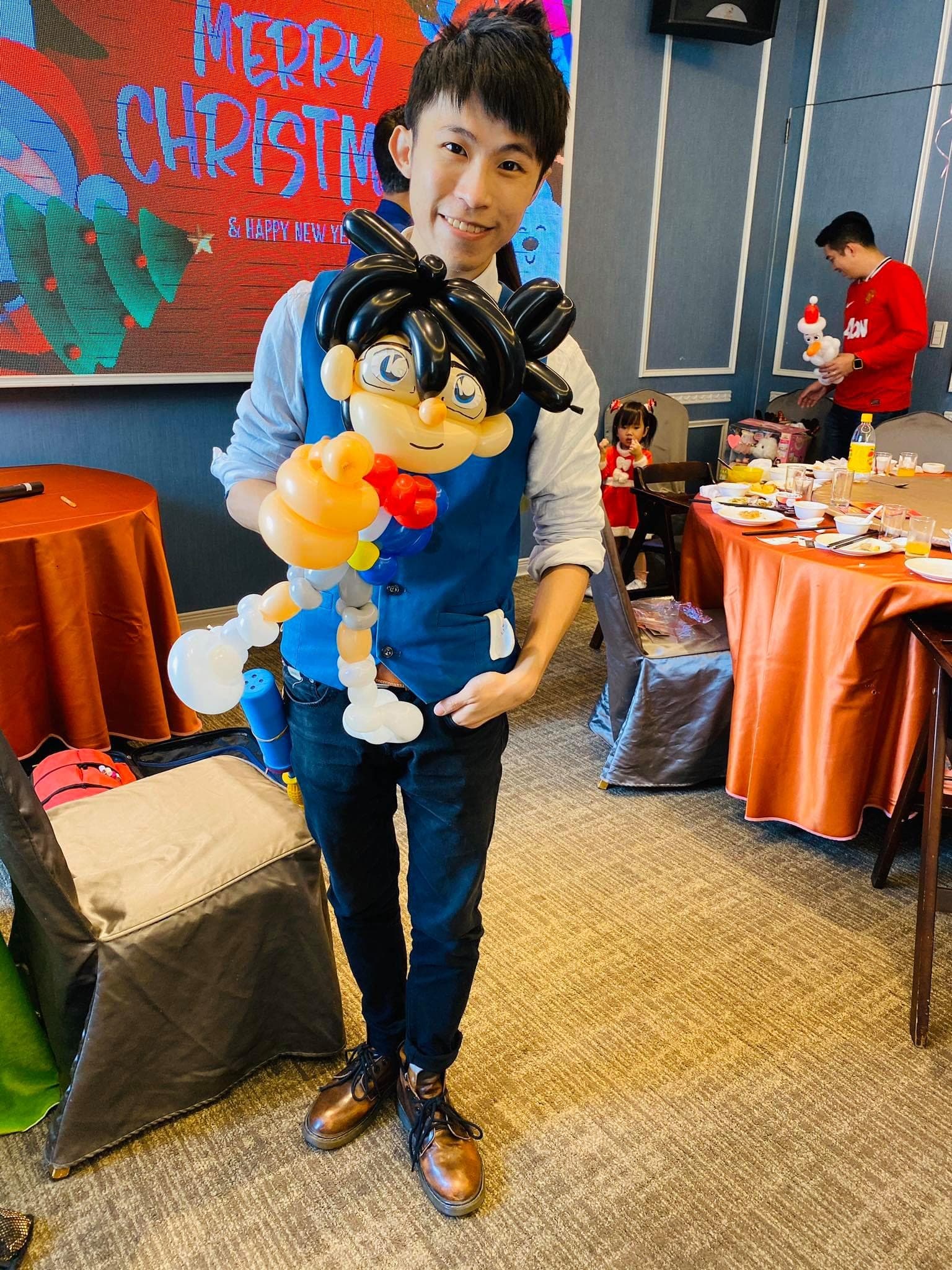 聖誕背板前，我抱著名偵探柯南造型氣球