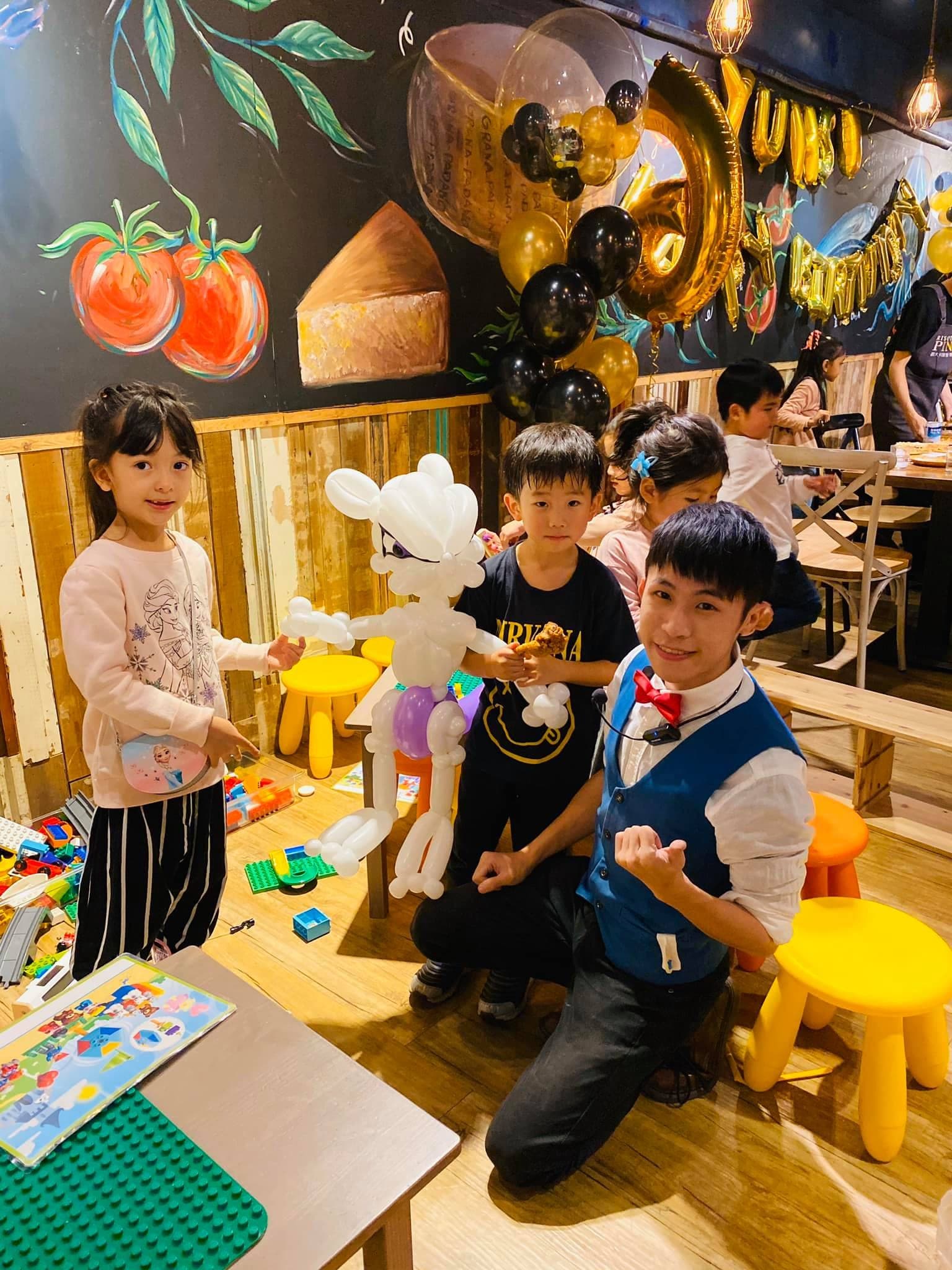 餐廳生日派對上，我蹲在孩子們旁邊，中間是超夢造型氣球