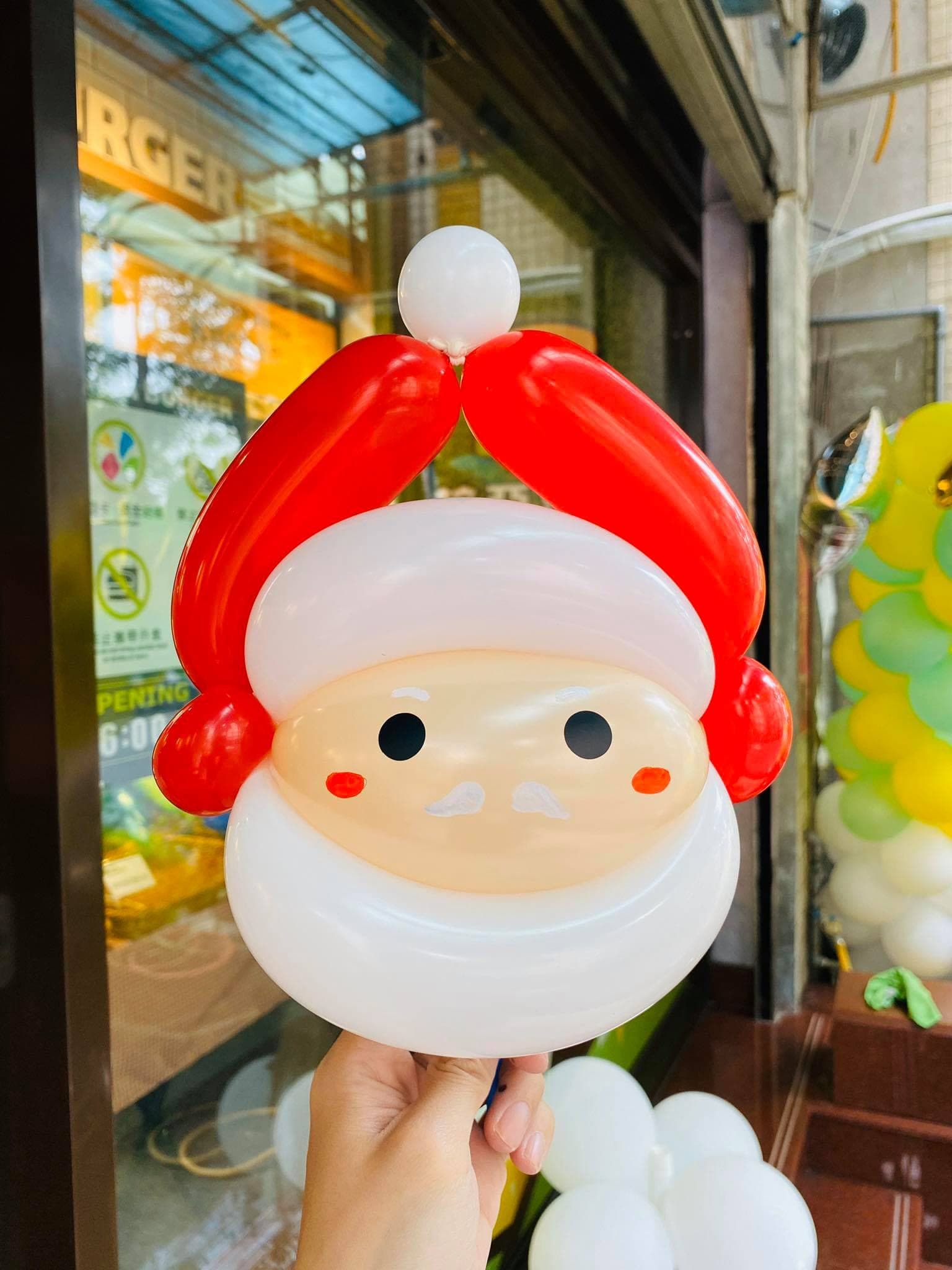 拉亞漢堡門市前，手拿聖誕老人臉造型氣球的特寫