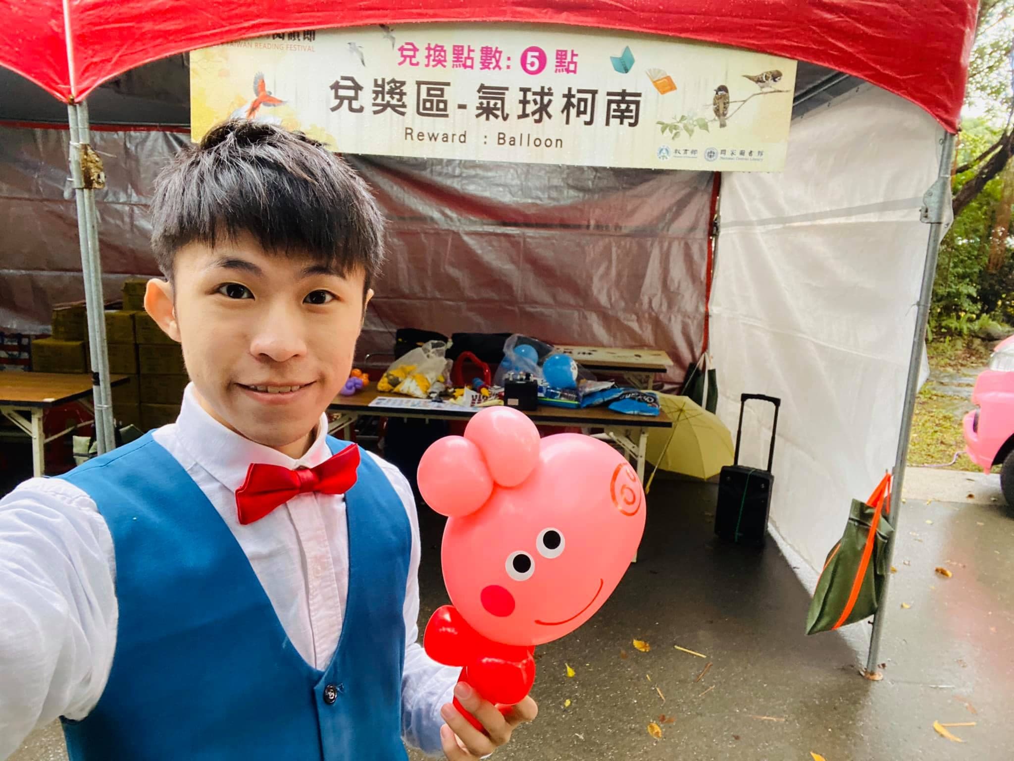 大安森林公園台灣閱讀節，「兌獎區—氣球柯南」帳篷前我拿著粉紅小豬氣球自拍