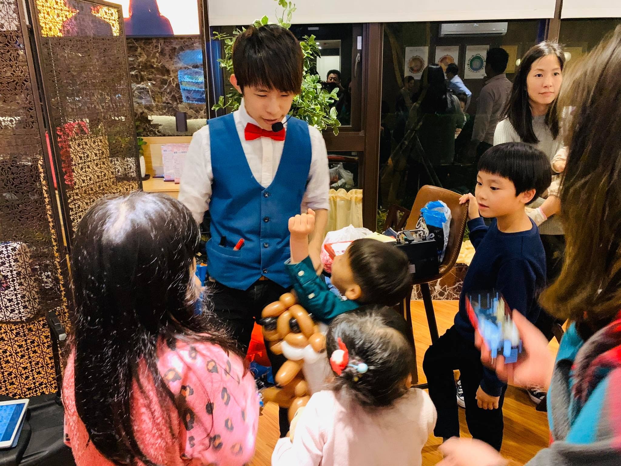 派對現場，我在桌邊幫圍過來的孩子折氣球