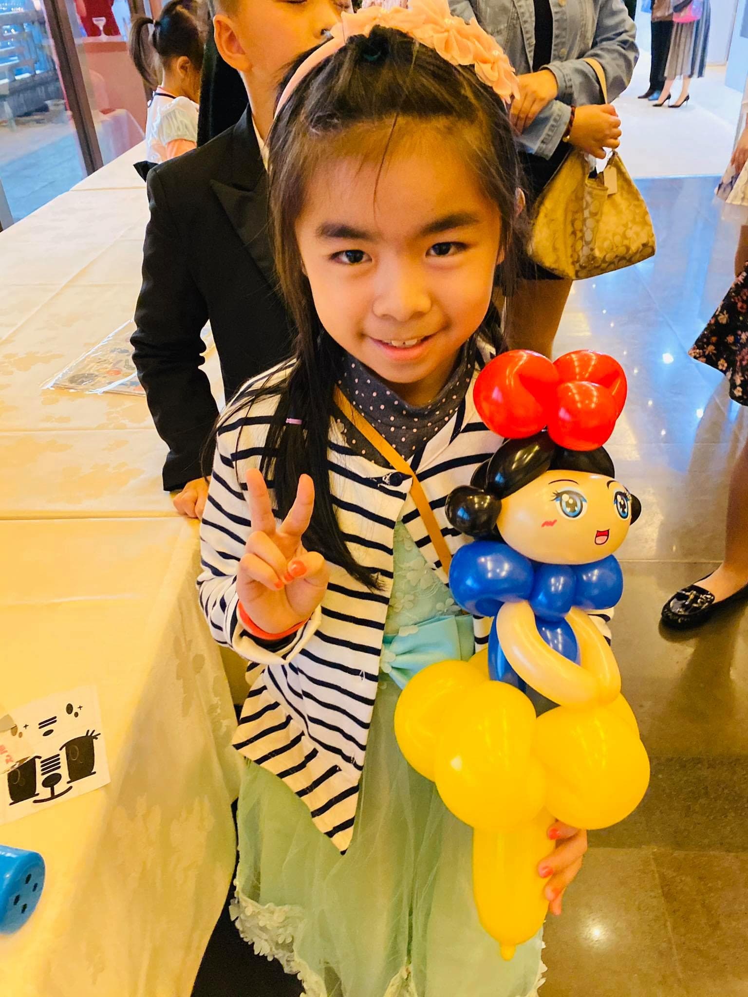 20 週年尾牙會場，穿條紋外套的女孩拿著白雪公主氣球比 YA