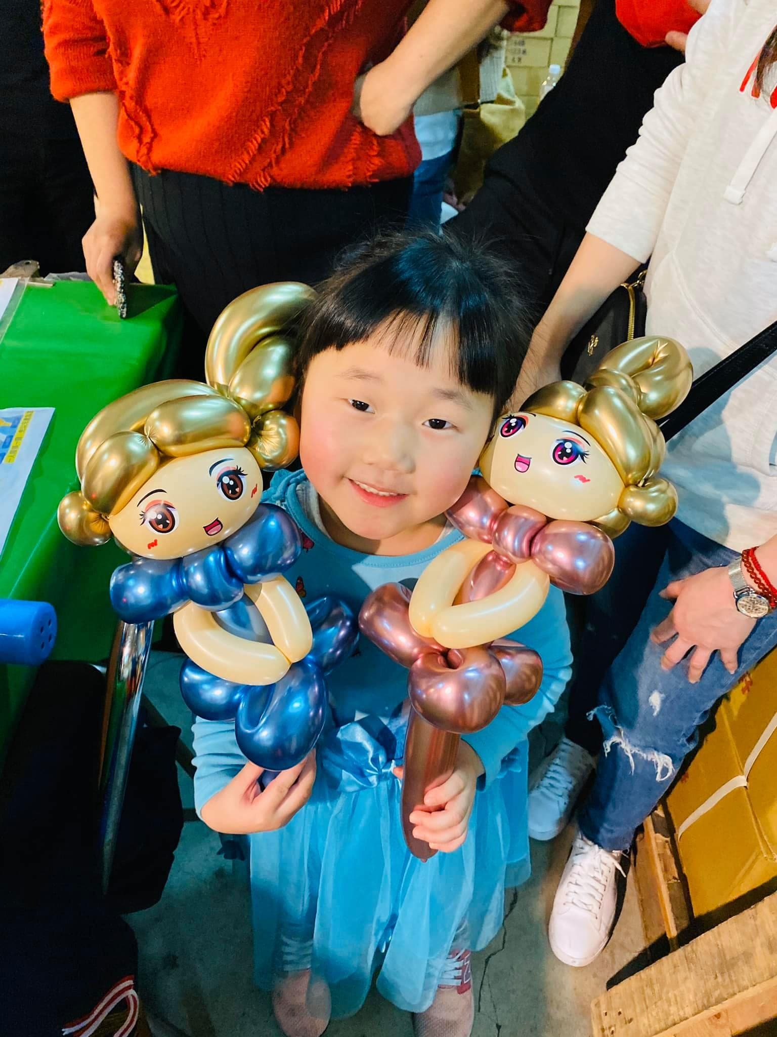 藍色紗裙女孩左右各抱一隻金髮公主，分別是金屬藍與玫瑰金禮服