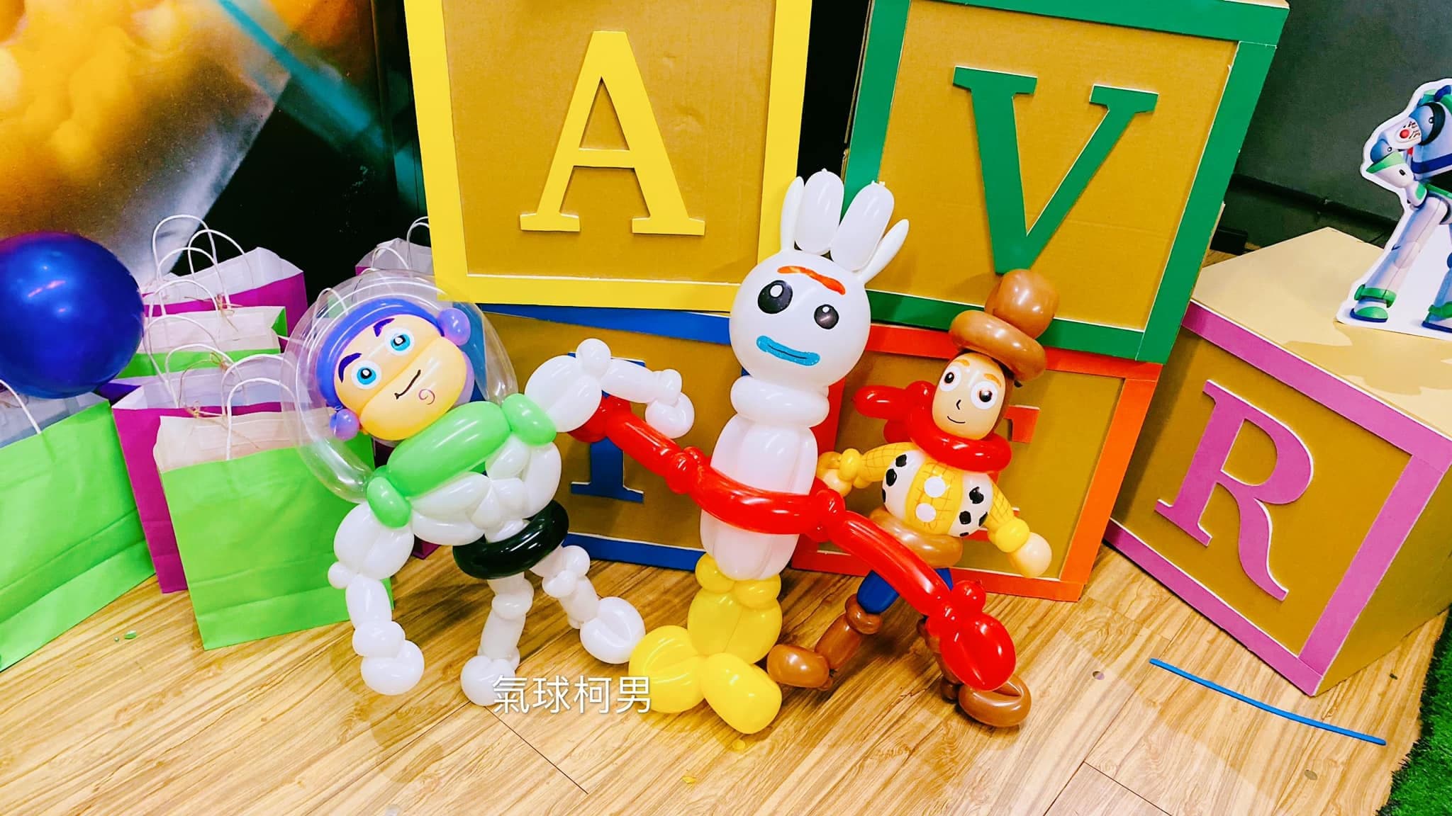巴斯光年、叉奇、胡迪三隻玩具總動員造型氣球擺在字母積木前