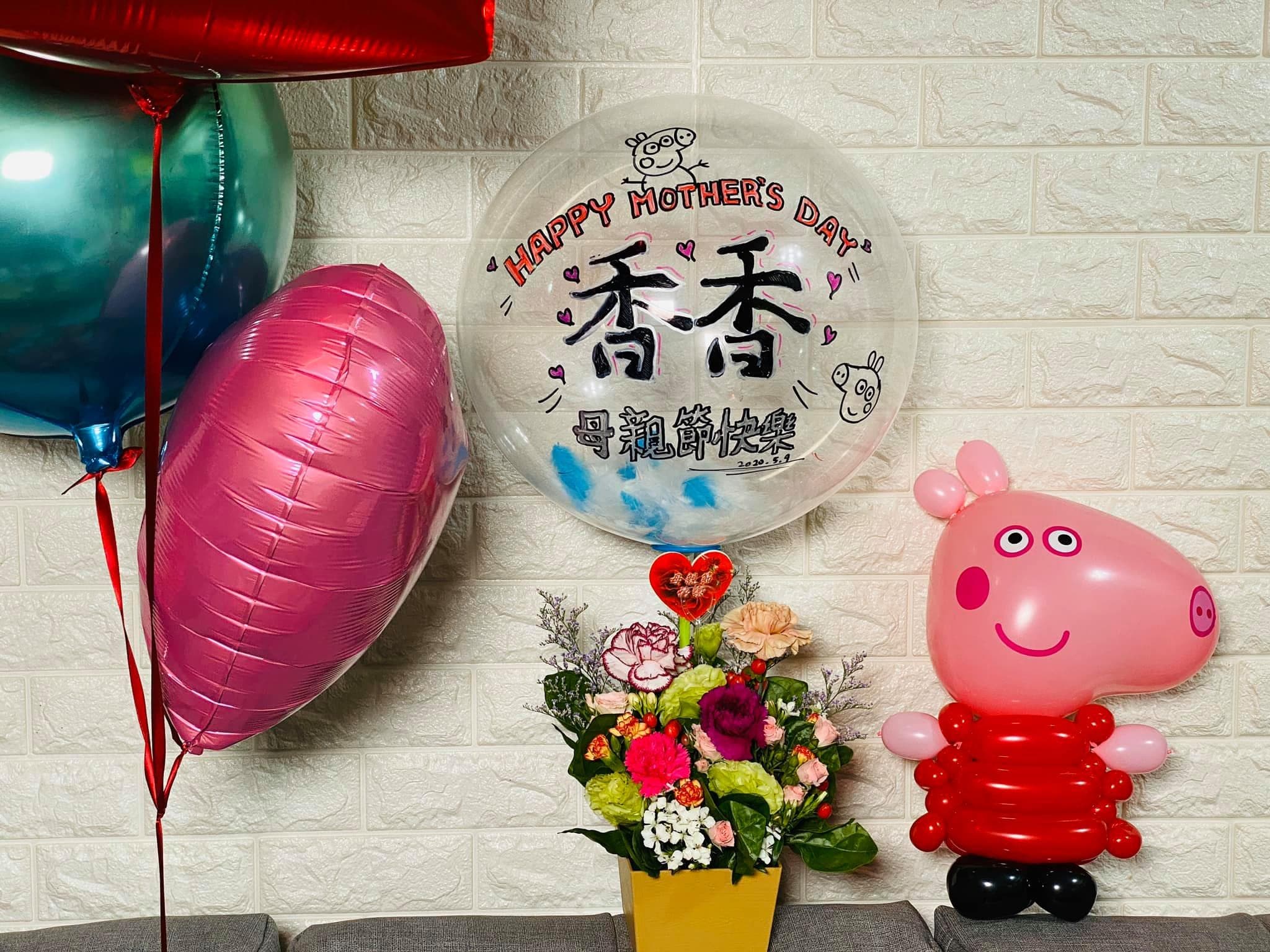 手繪「香香 母親節快樂」透明氣球插在盆花上，旁邊是佩佩豬造型氣球