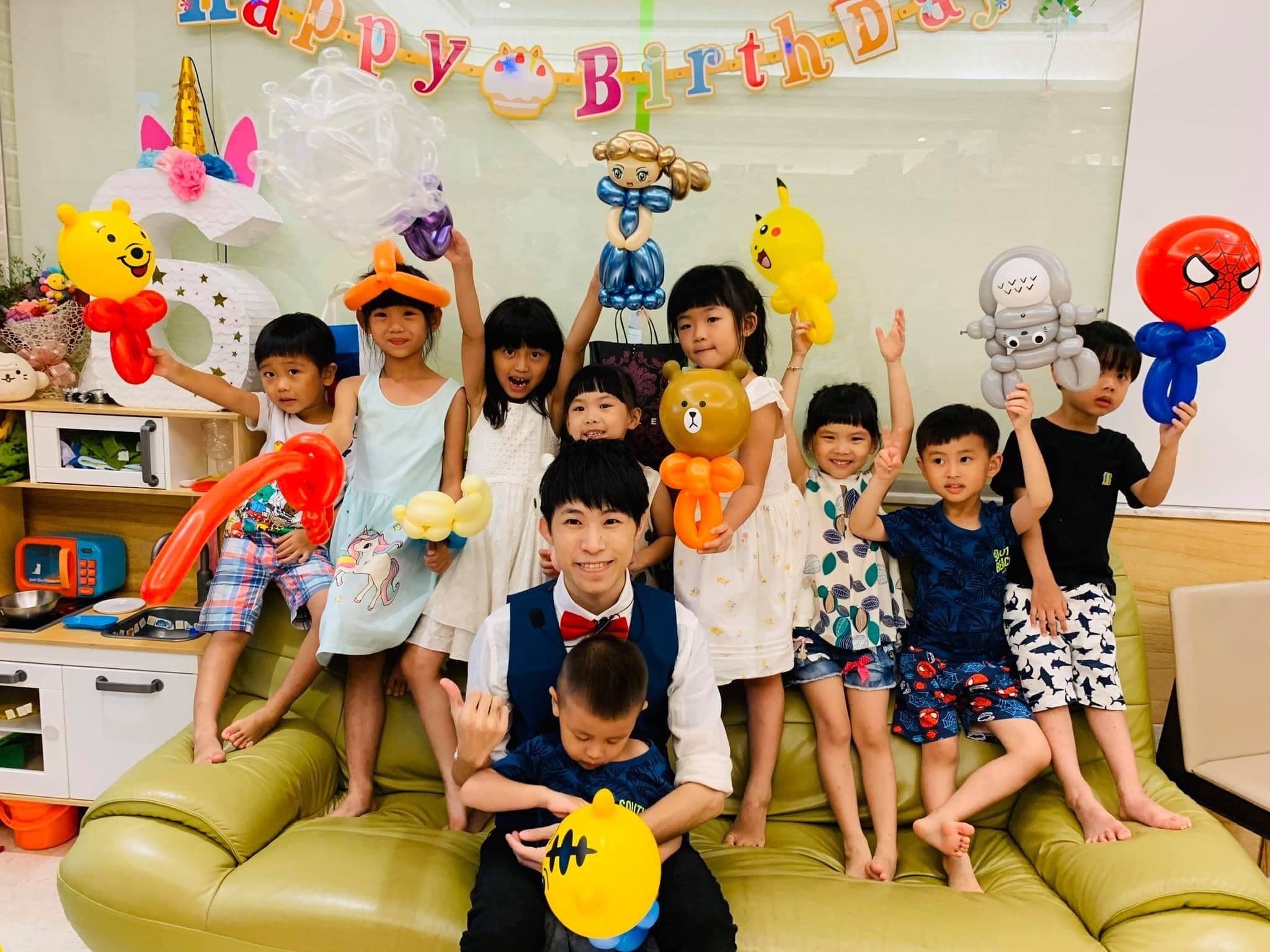 台北住家生日派對，小朋友站在沙發上舉著維尼、皮卡丘等造型氣球