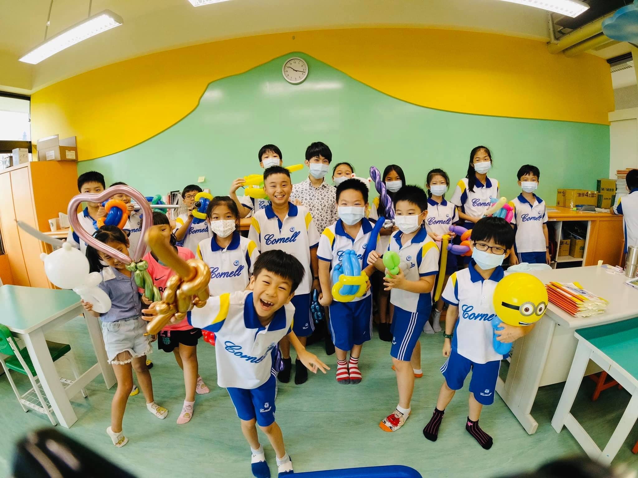 穿白藍制服的小學生拿著金色寶劍與小小兵氣球歡呼