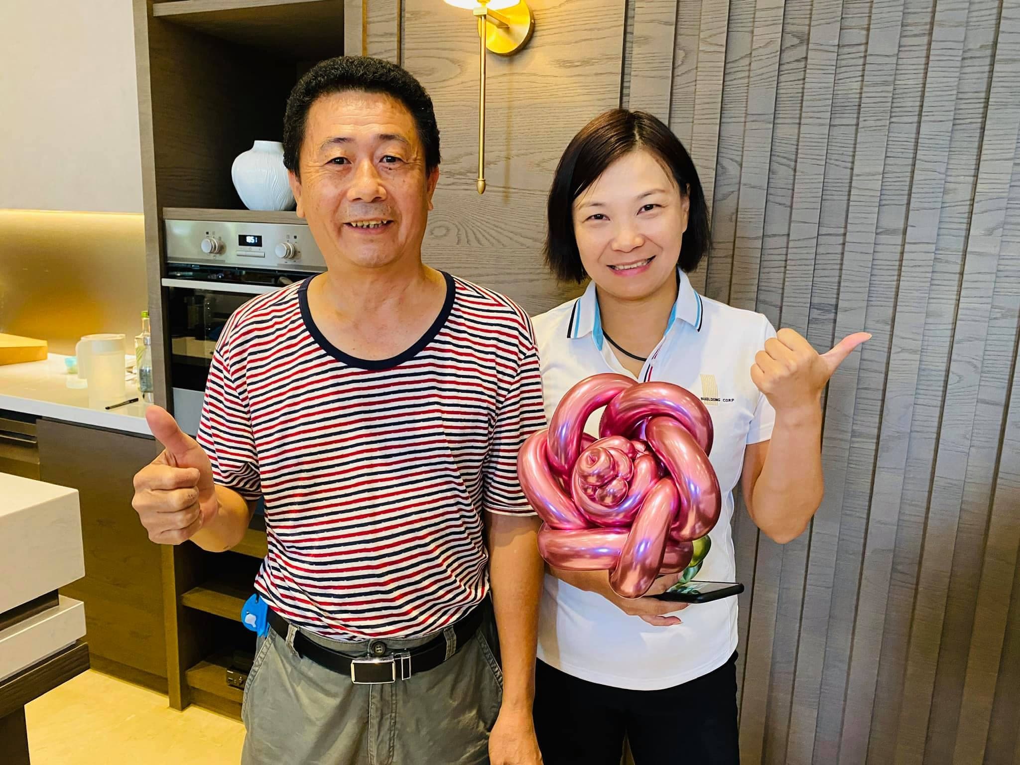兩位大人比讚，女士捧著玫瑰金屬色大朵氣球玫瑰