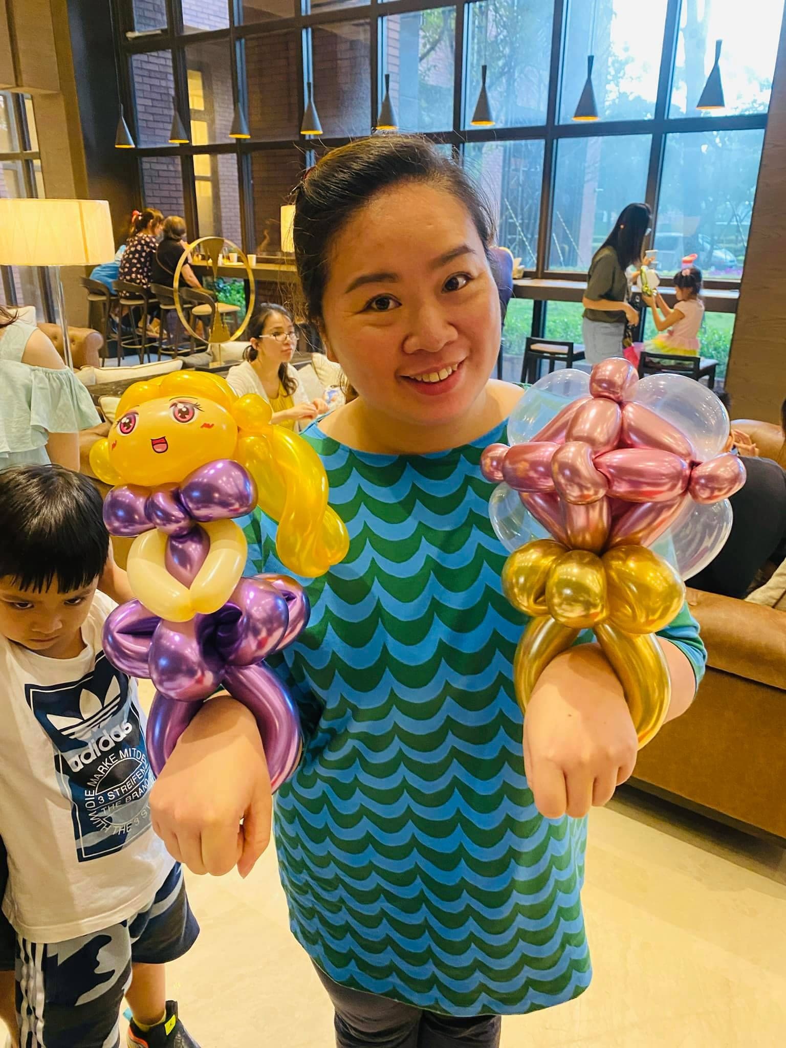 女士手上戴著金髮紫裙公主與粉金色花朵氣球手環