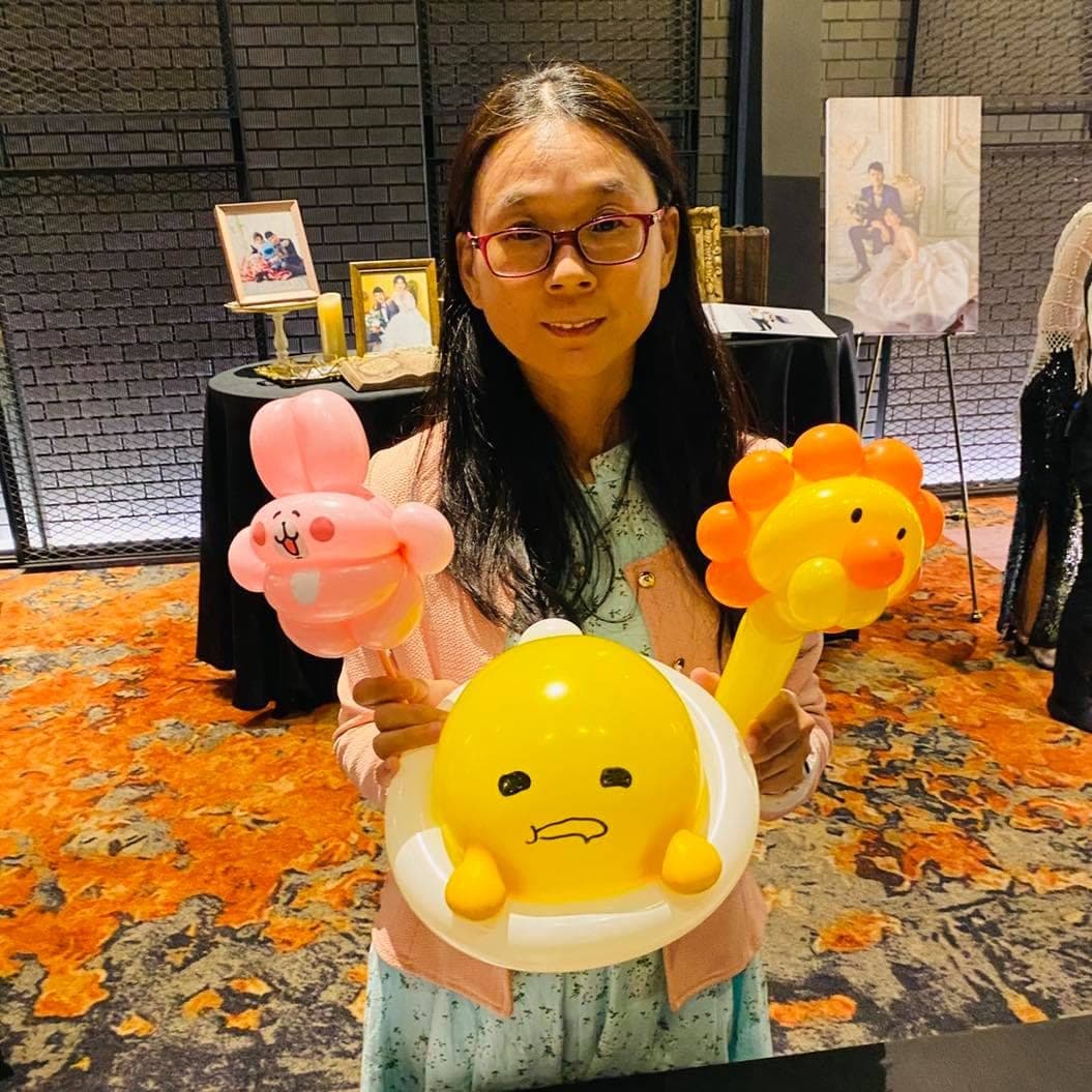 女士一次拿著卡娜赫拉粉紅兔兔、蛋黃哥與小獅子氣球