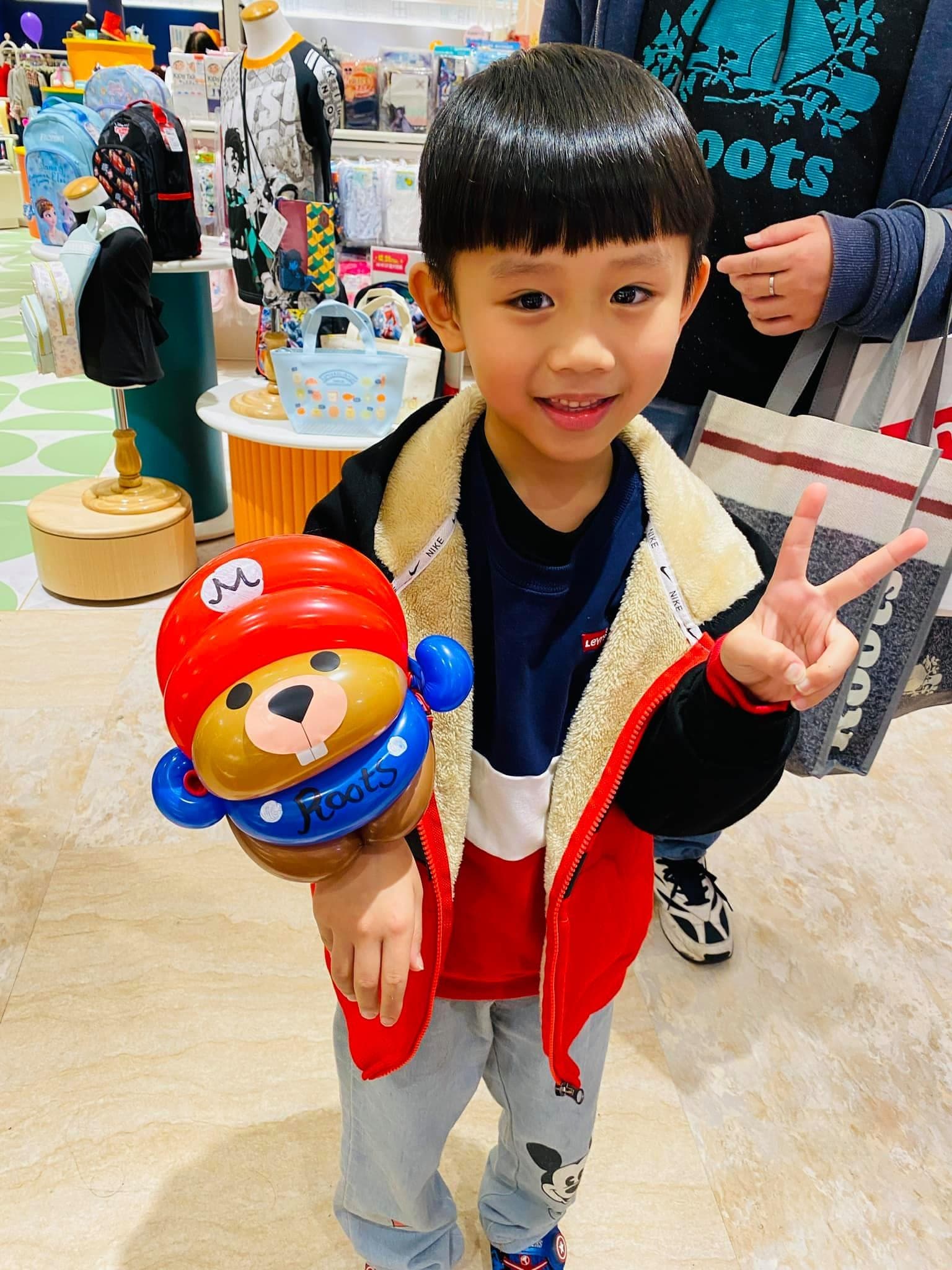 比 YA 的男孩手上套著瑪利歐 M 字帽海狸氣球