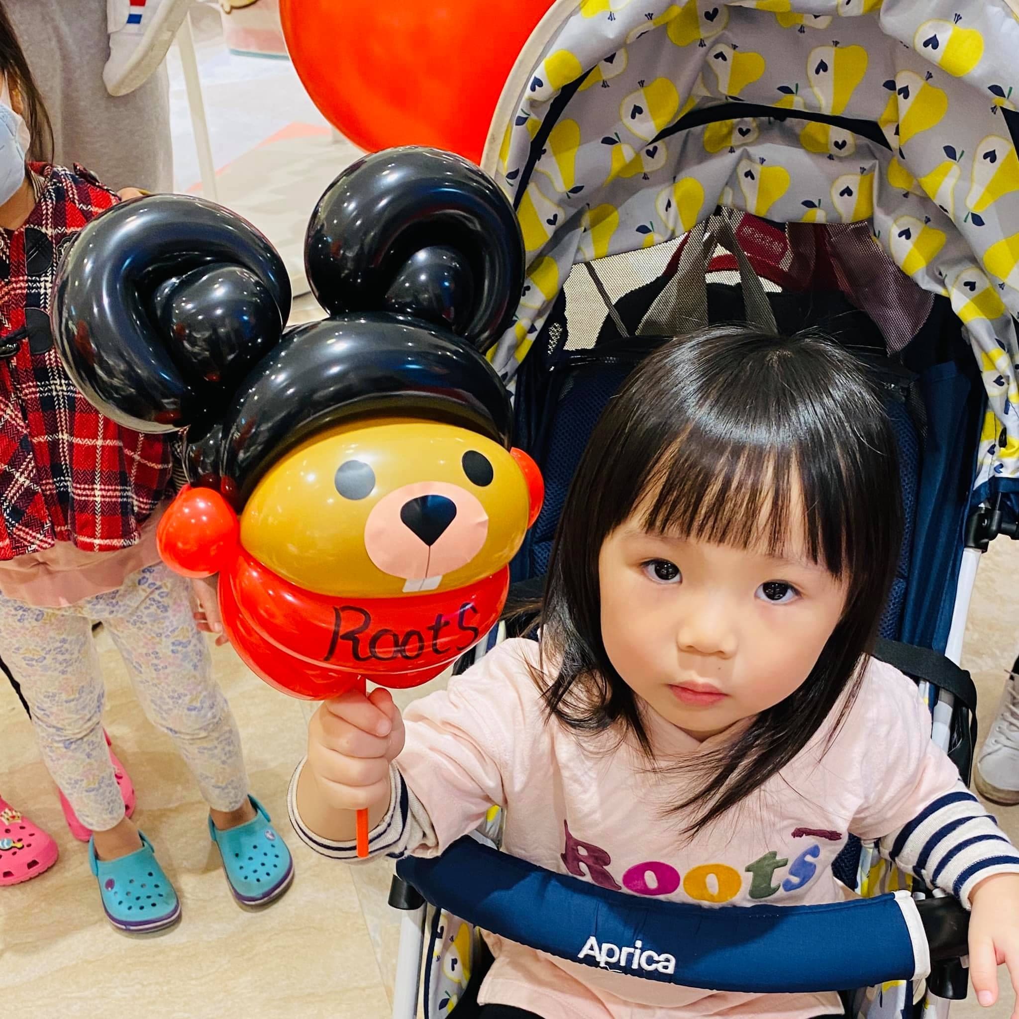 推車上的小女孩拿著米奇耳朵造型的海狸氣球