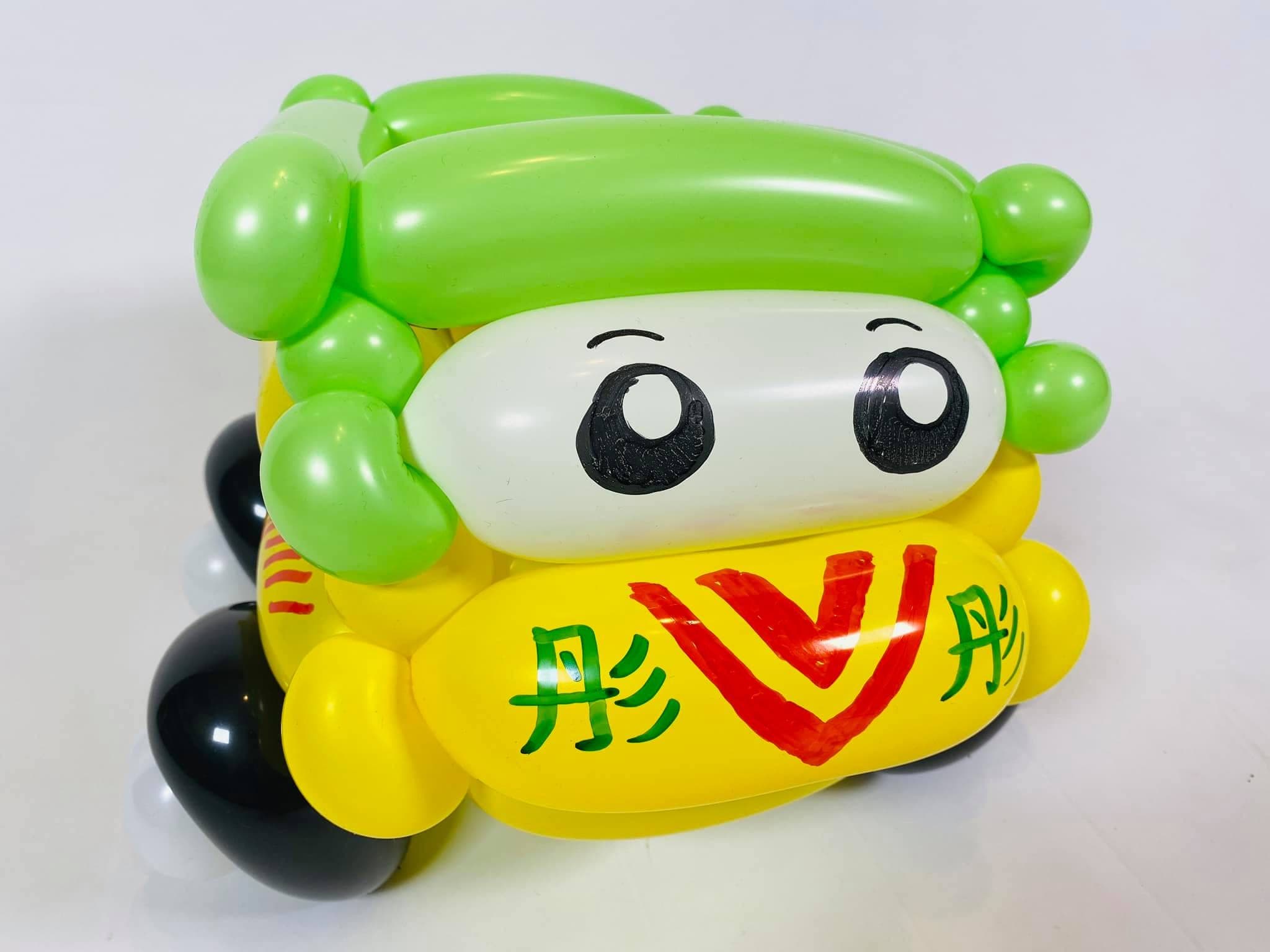 黃色車身綠色車頂的娃娃車造型氣球，車頭寫著壽星名字