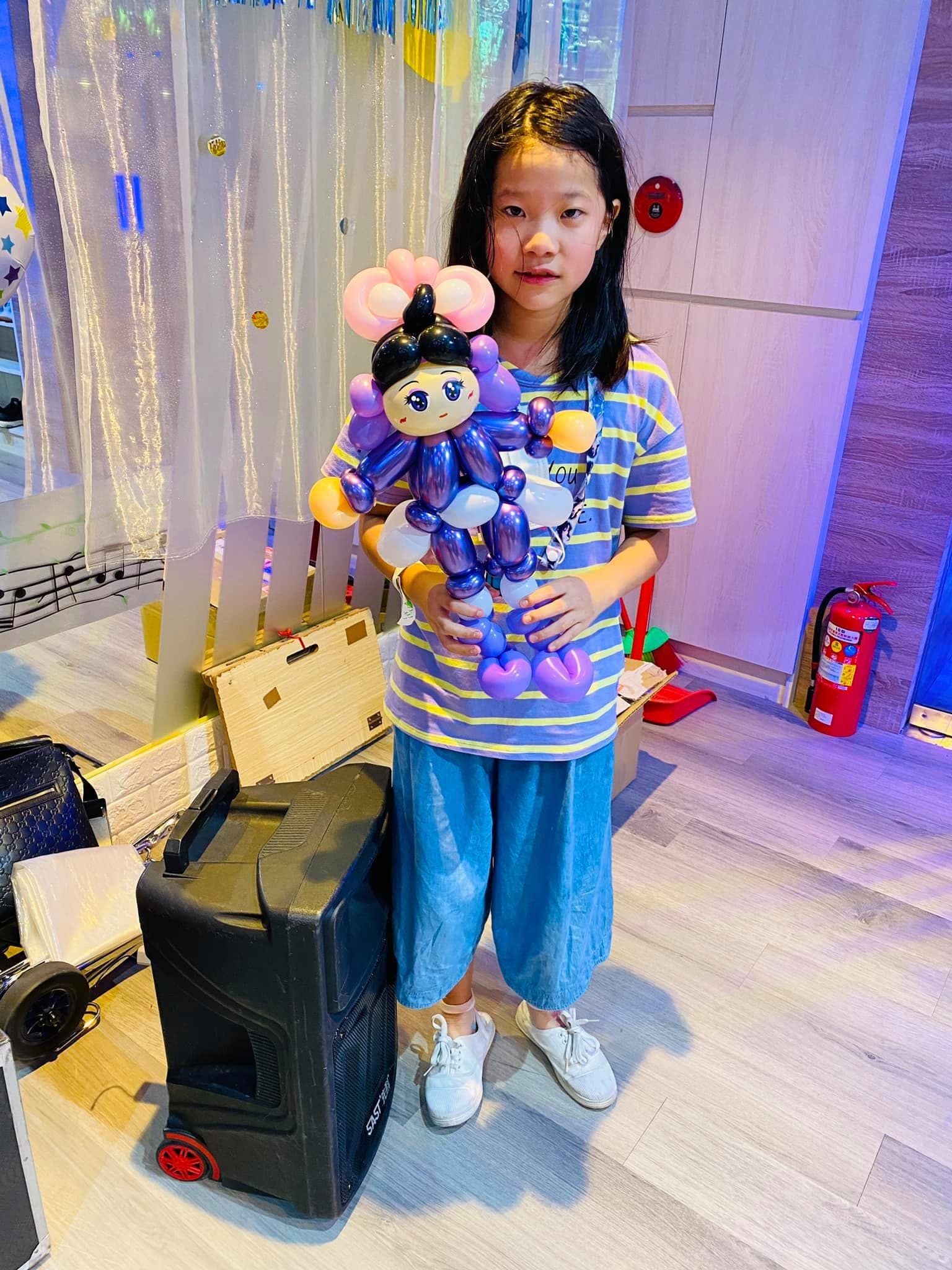 女孩抱著紫色系的香奈乎造型氣球站在派對空間