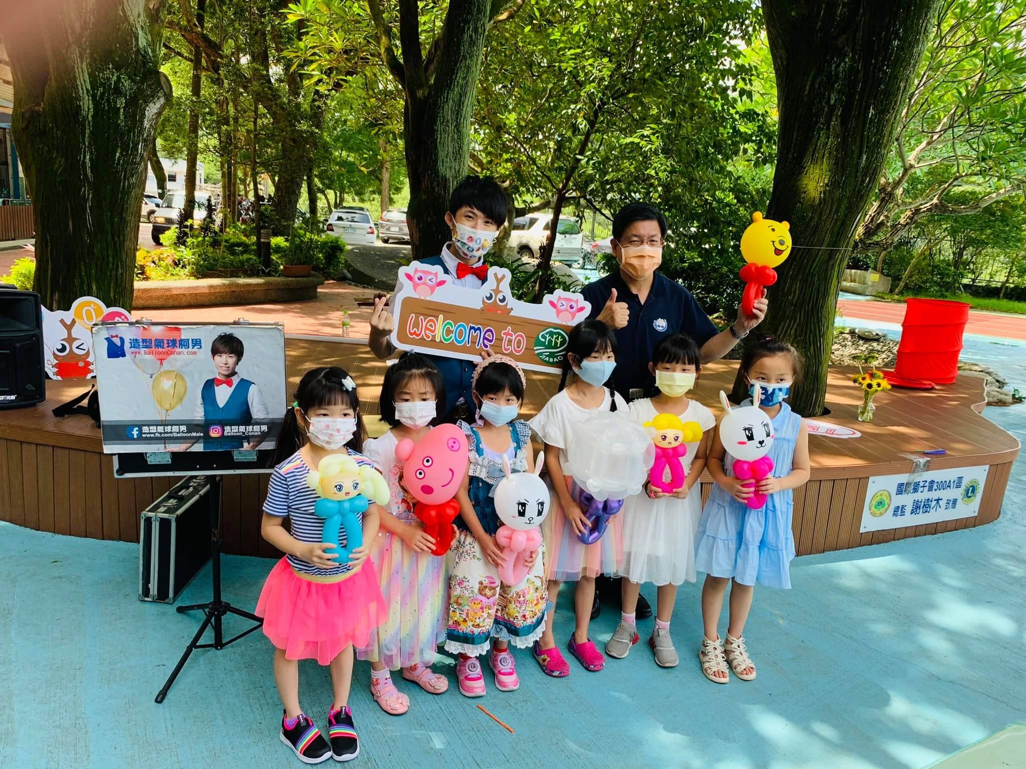 女孩們拿著公主、卡娜赫拉粉紅兔兔、Hello Kitty 氣球，柯男舉 Welcome 牌