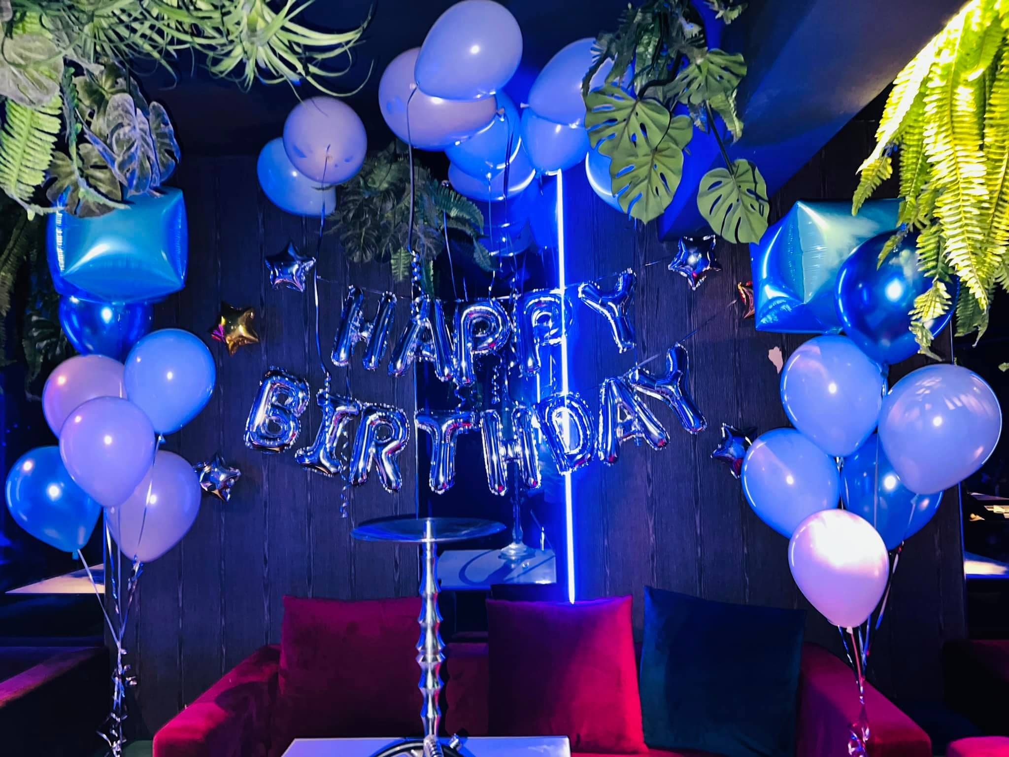 酒吧卡座牆上的銀色 HAPPY BIRTHDAY 字母與兩側藍紫空飄氣球