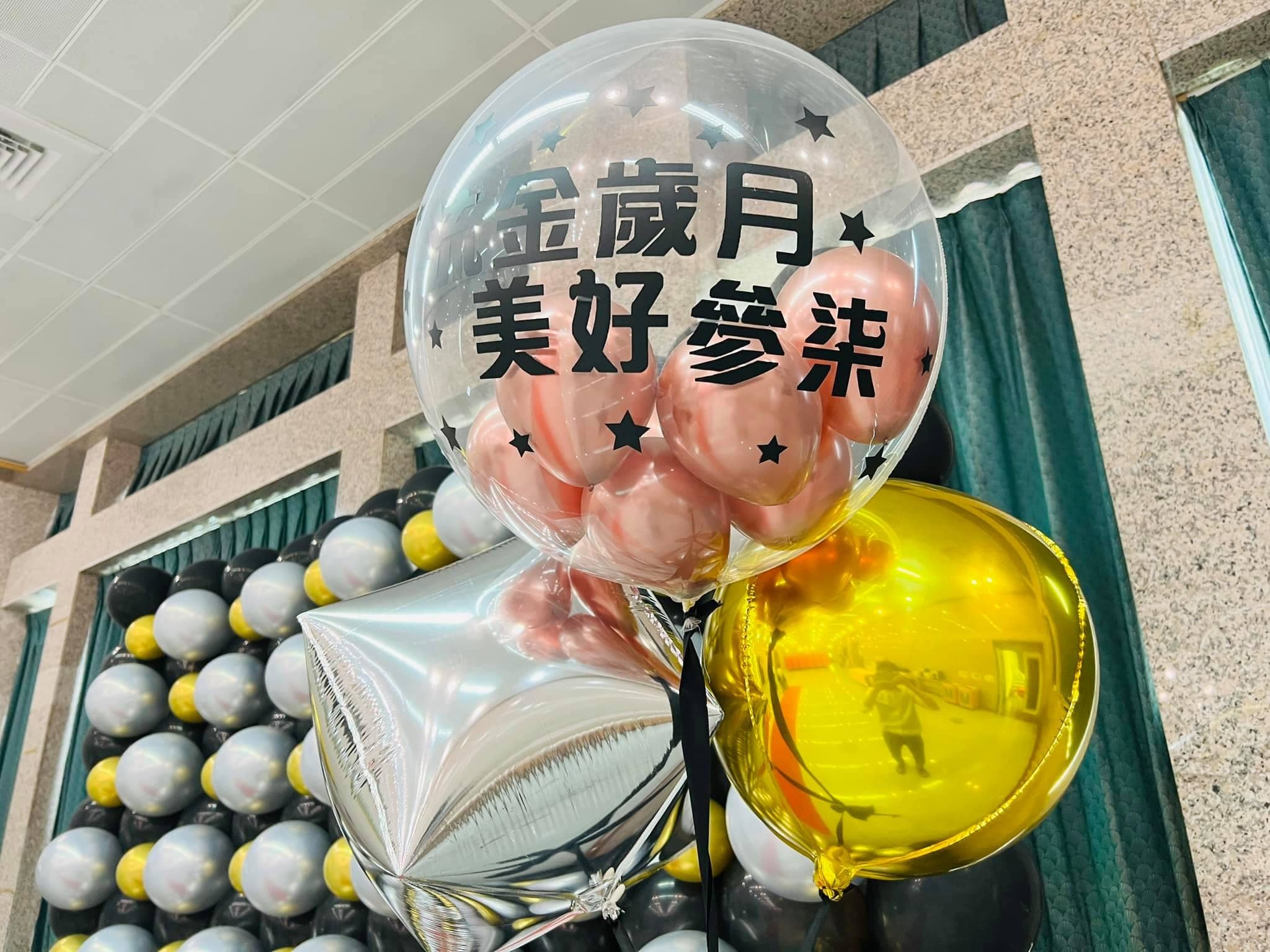 印著「流金歲月 美好參柒」的客製透明氣球，配銀色星星與金色圓球
