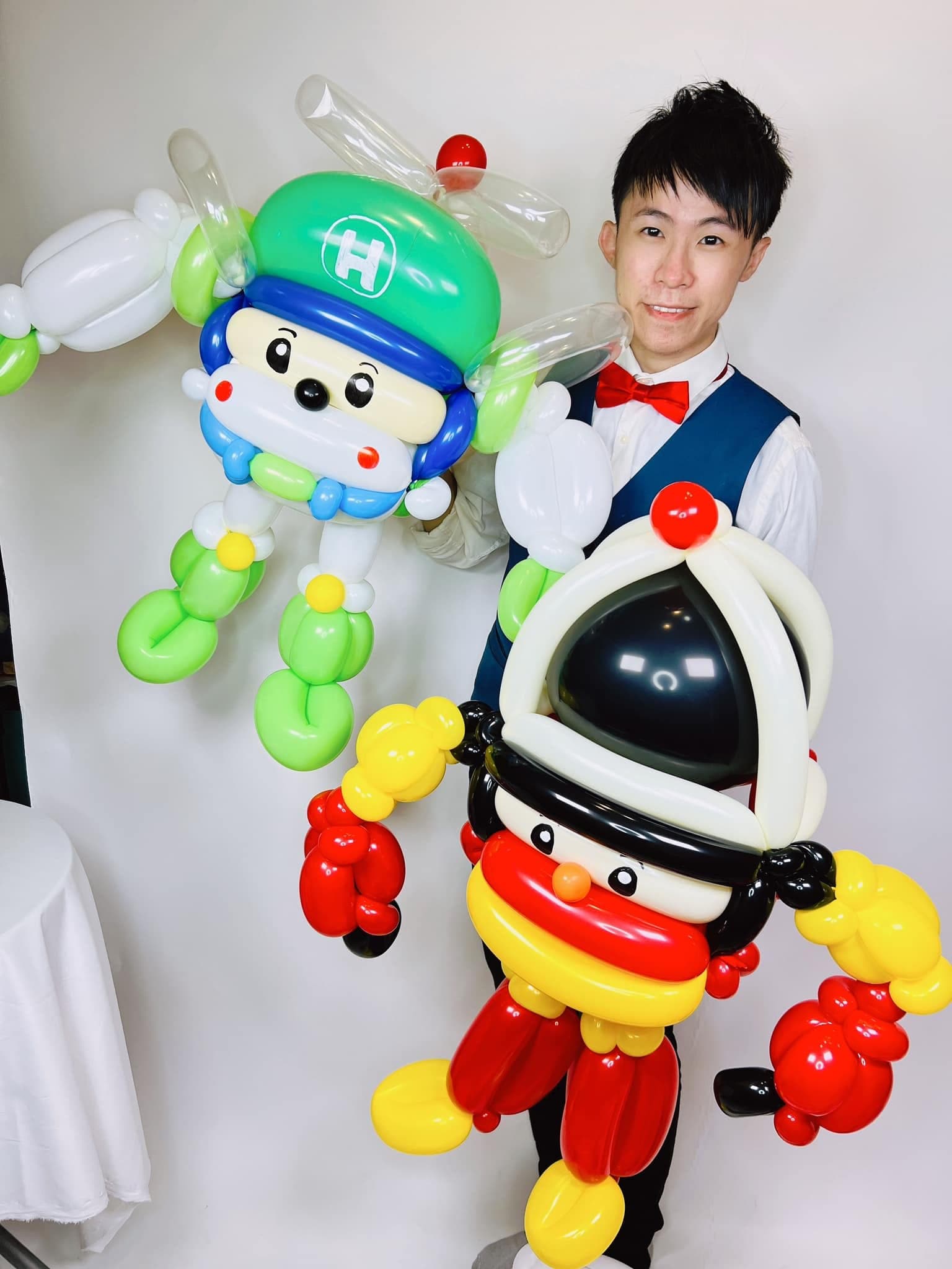 柯男拿著綠色直升機赫利與紅黃色羅伊兩隻氣球人偶