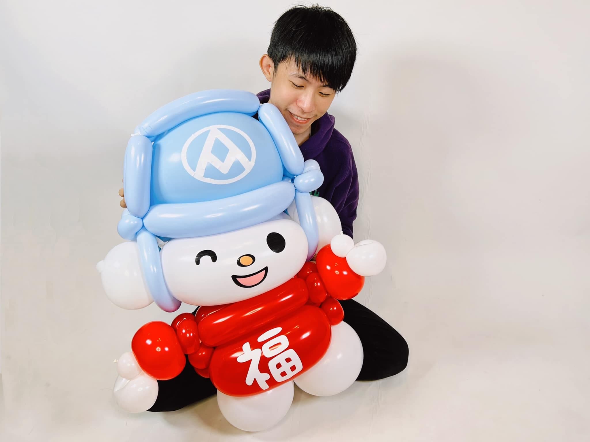 柯男坐在地上，抱著大型福利熊氣球人偶