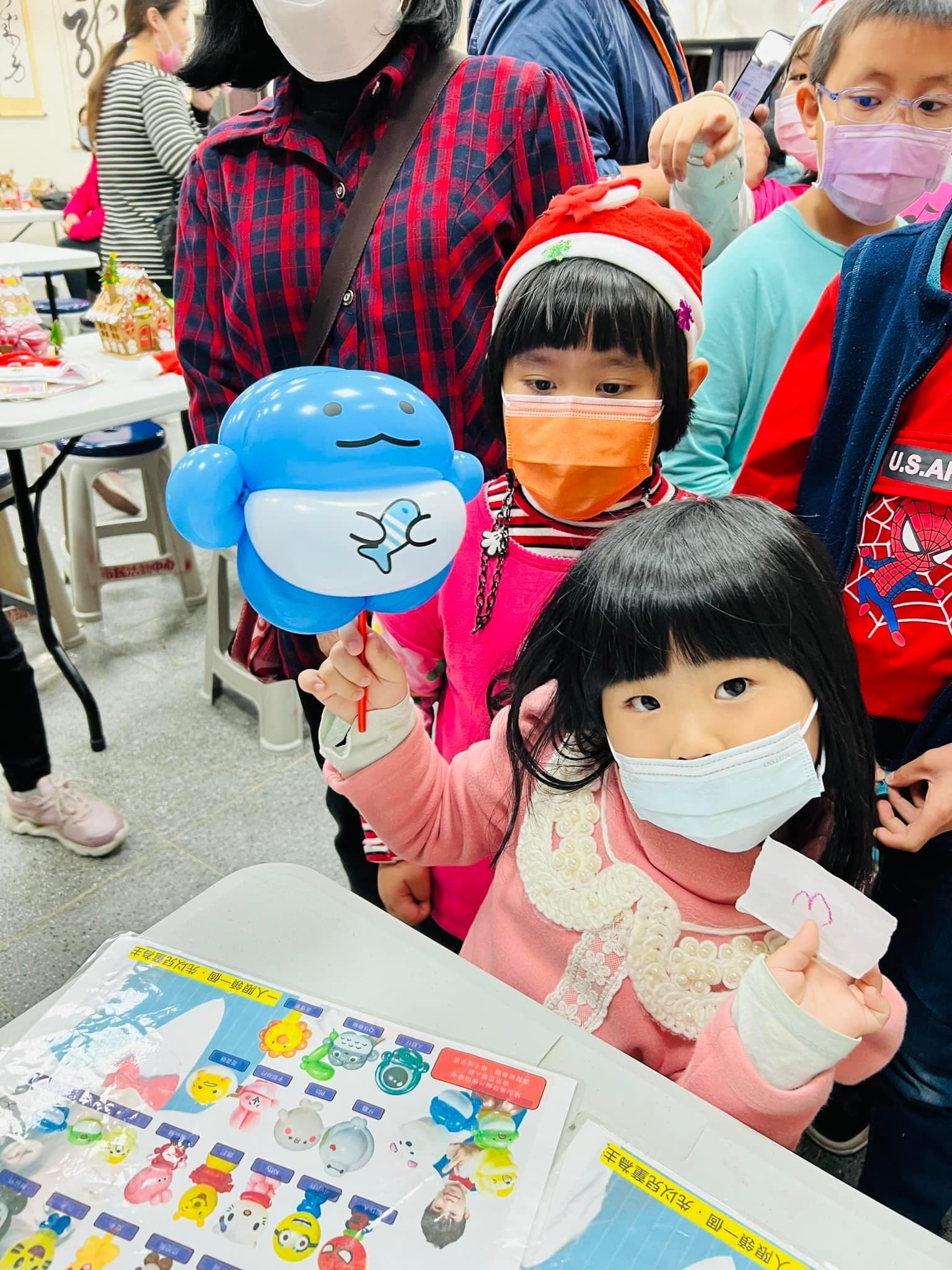 小女孩拿著肚子印小魚圖案的藍色圓胖造型氣球