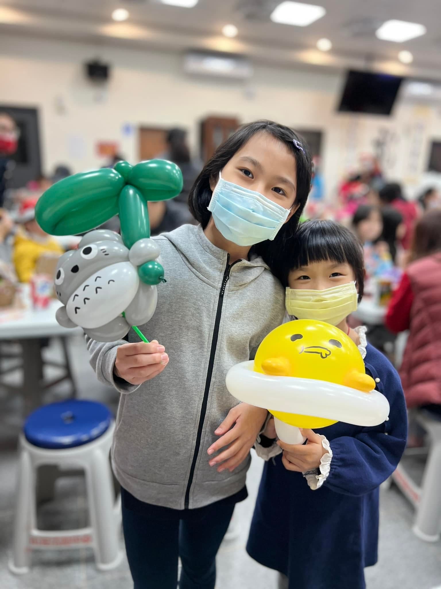 姊妹拿著撐葉子的龍貓與蛋黃哥造型氣球