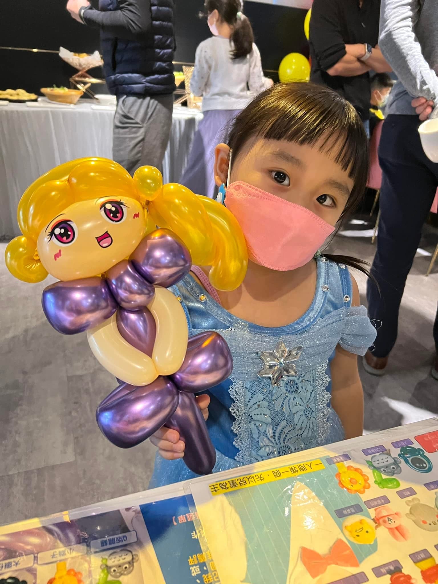小女孩拿著金髮紫色衣服的公主造型氣球