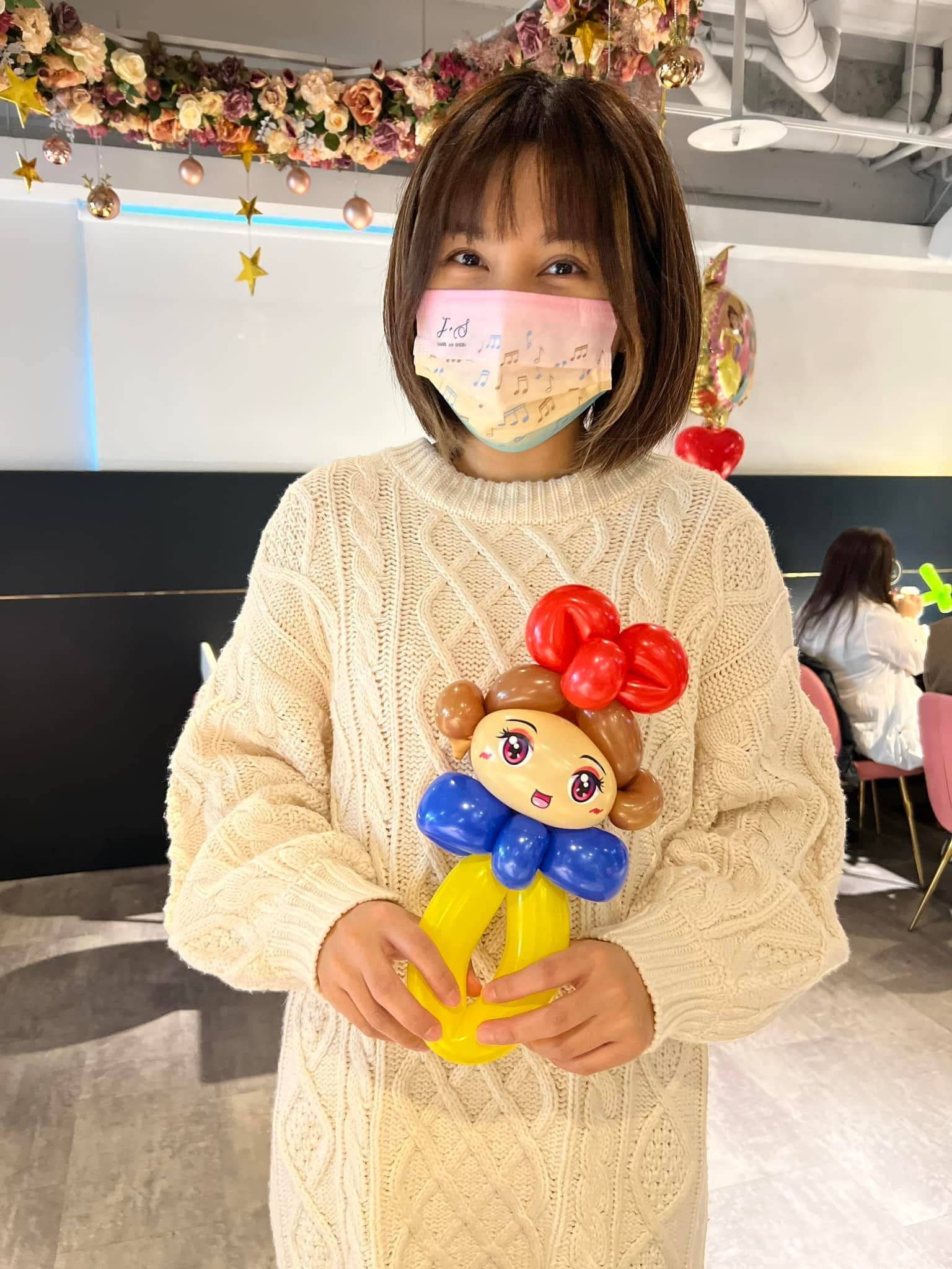 賓客捧著白雪公主造型氣球，紅色蝴蝶結與藍黃衣服