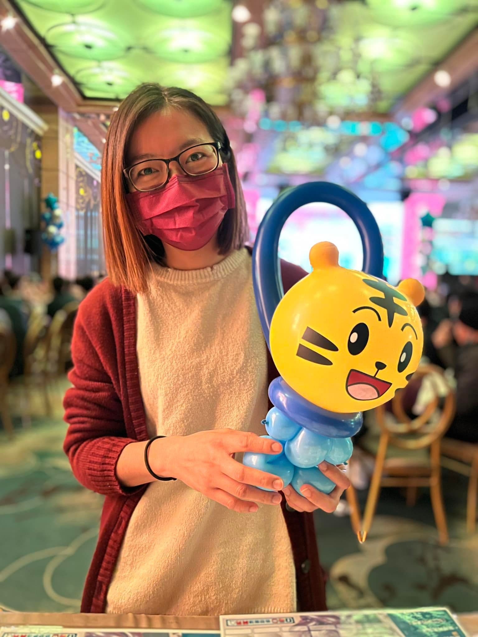 賓客拿著黃色小老虎提把造型氣球，應景虎年