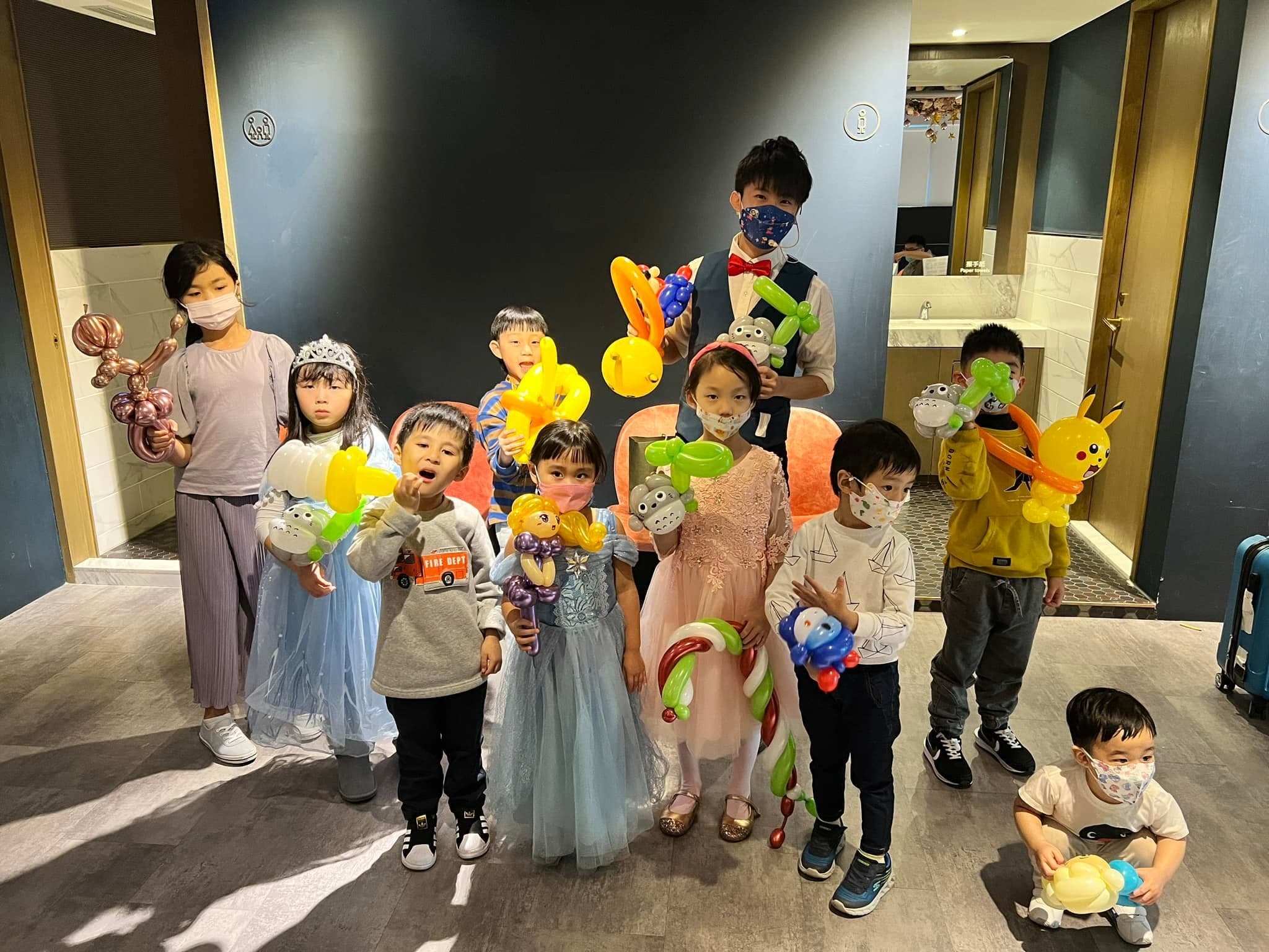 小朋友們拿著皮卡丘、公主等造型氣球，在餐廳與柯男合照