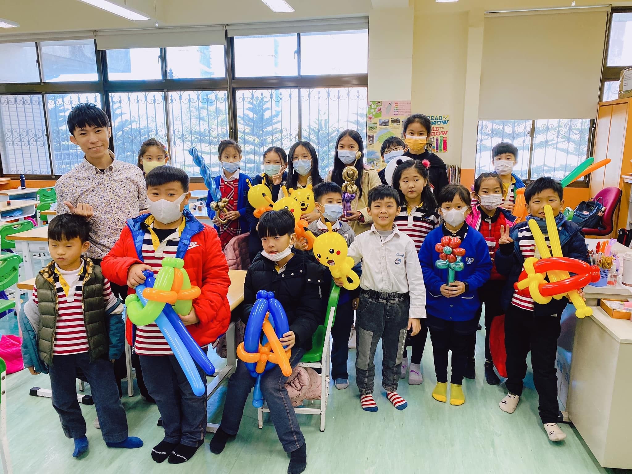 2021年魔術社另一班學生拿著寶劍、小熊等氣球合照