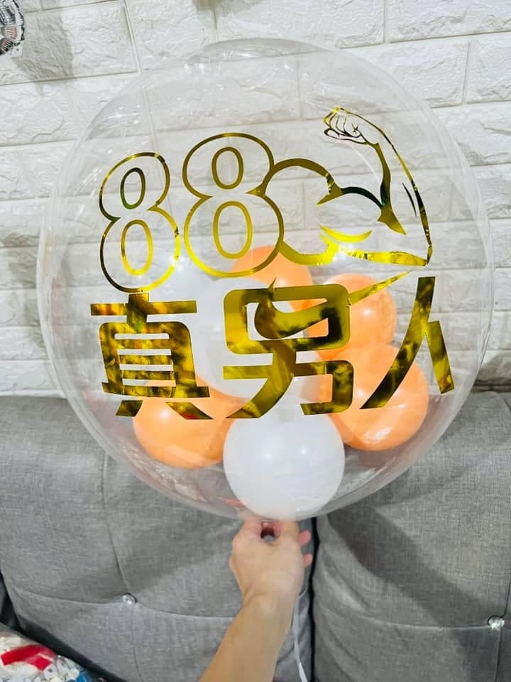 透明泡泡氣球上貼著金色 88 真男人字樣，裡面是橘色小氣球