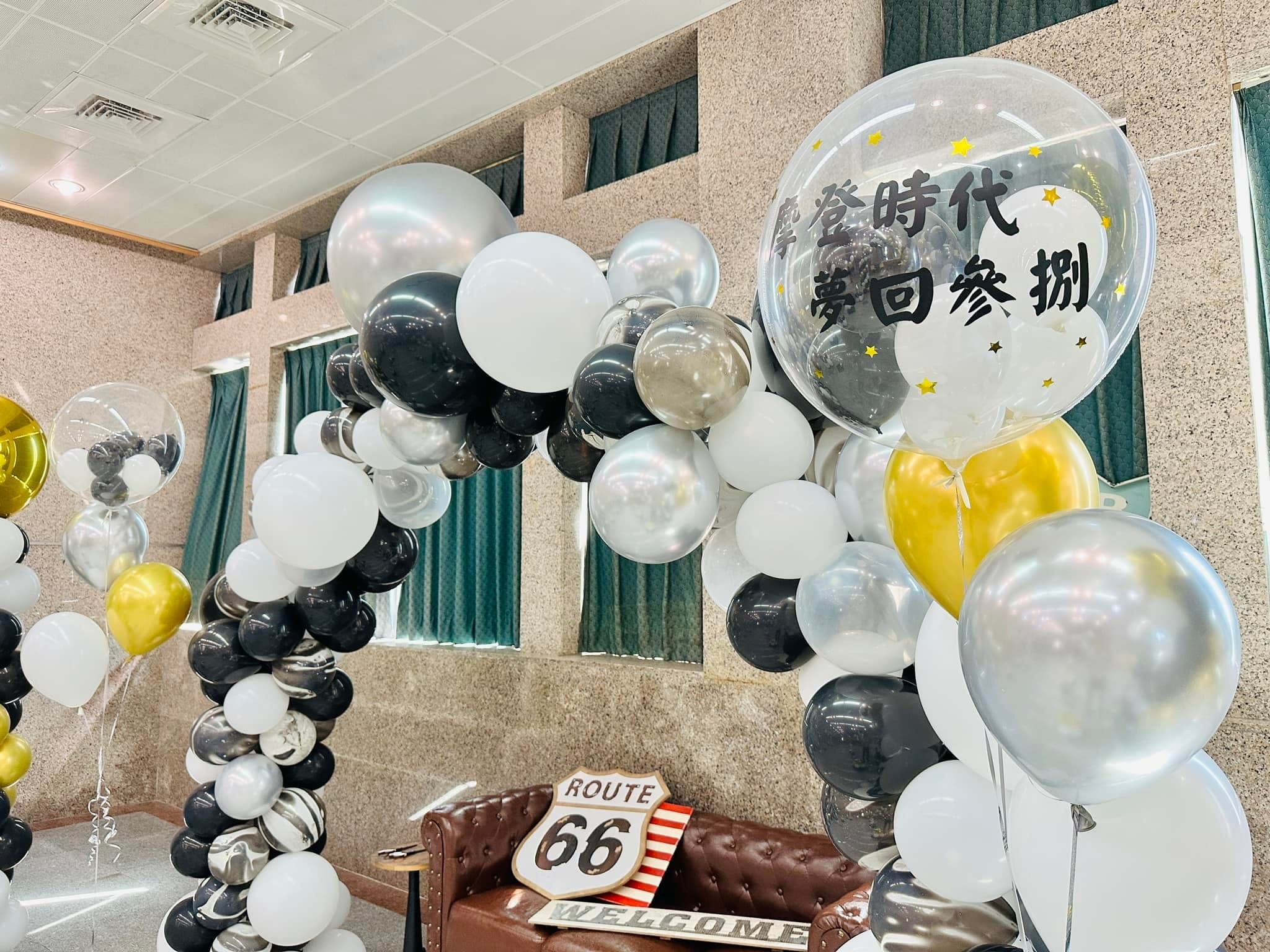 氣球拱門上的透明泡泡球寫著摩登時代主題字，下方是 Route 66 路牌